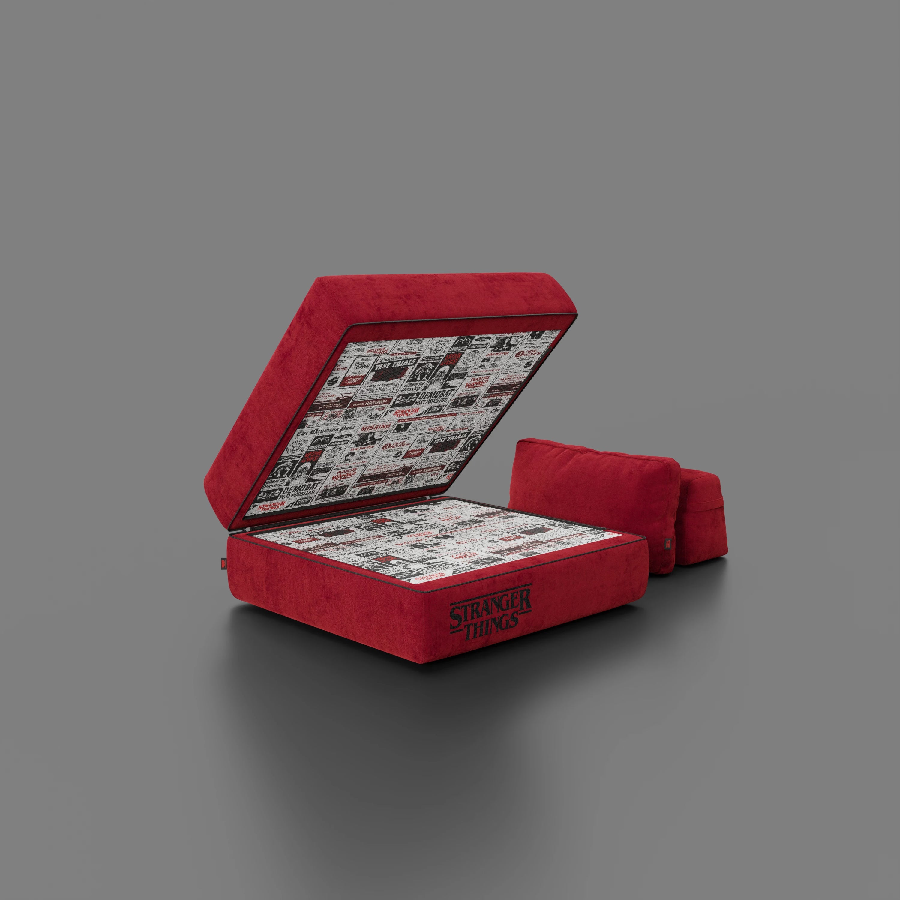 Una poltrona letto Rift rossa STRANGER THINGS Edition di Divani.Store, con materasso in memory foam da 22 cm e tessuto antimacchia, viene aperta per rivelare un interno ispirato ai fumetti. La scritta "Stranger Things" appare sulla struttura; due cuscini coordinati completano la scena.