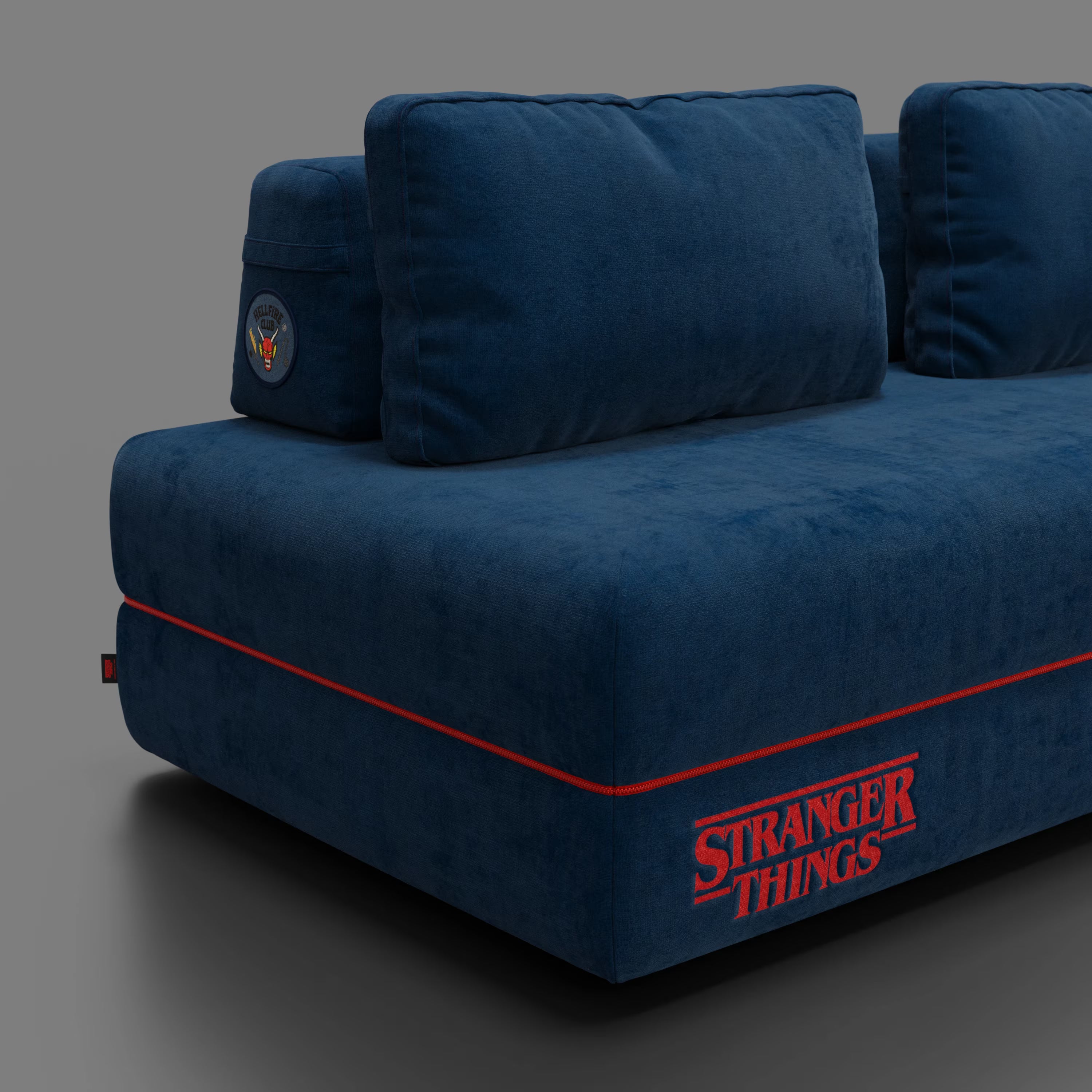 Il divano letto matrimoniale Rift STRANGER THINGS Edition di Divani.Store, in tessuto blu antimacchia con schienale mobile e materasso in memory foam, è caratterizzato da profili rossi, ricamo del logo e patch Hawkins per un dettaglio unico.