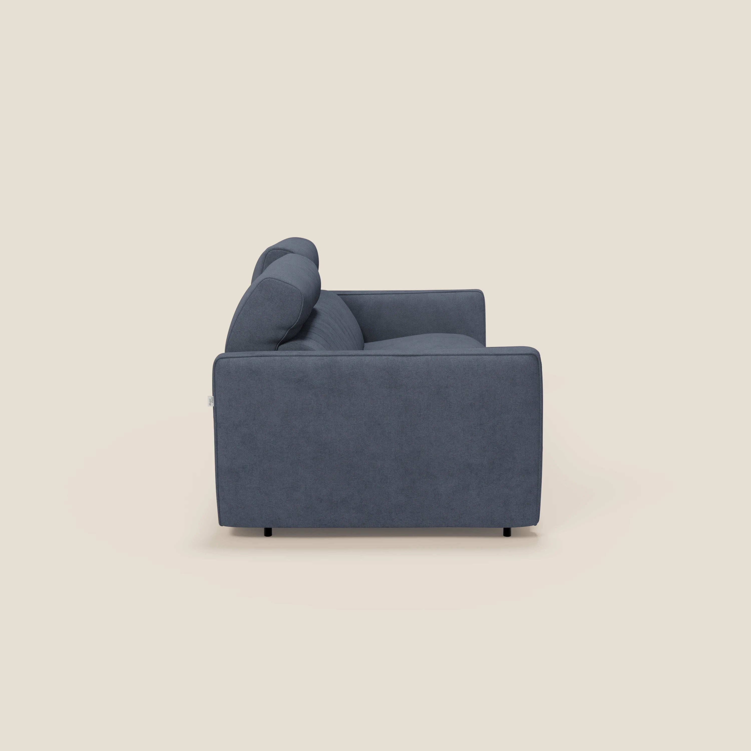 Vista laterale del divano letto Nivon Divano moderno di Divani.Store in tessuto impermeabile T25 blu denim, con cuscini in feltro, braccioli e poggiatesta regolabile. La forma squadrata e le corte gambe nere completano il suo design contemporaneo.