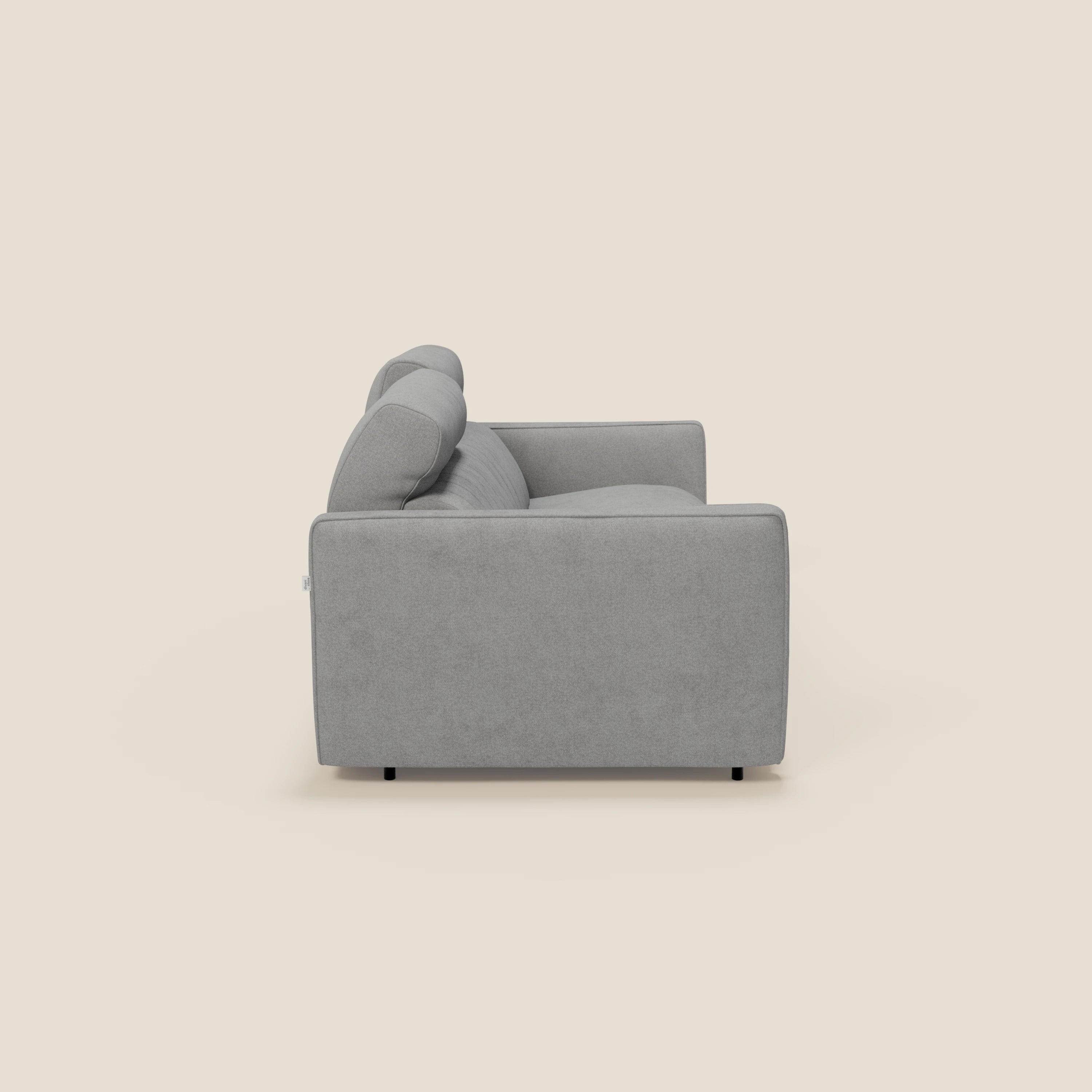 Il divano letto moderno Nivon di Divani.Store è presentato lateralmente su uno sfondo beige chiaro, con un materasso in peluche H16 cm, un bracciolo squadrato e un tessuto impermeabile grigio T25 con piedini neri corti appena visibili.