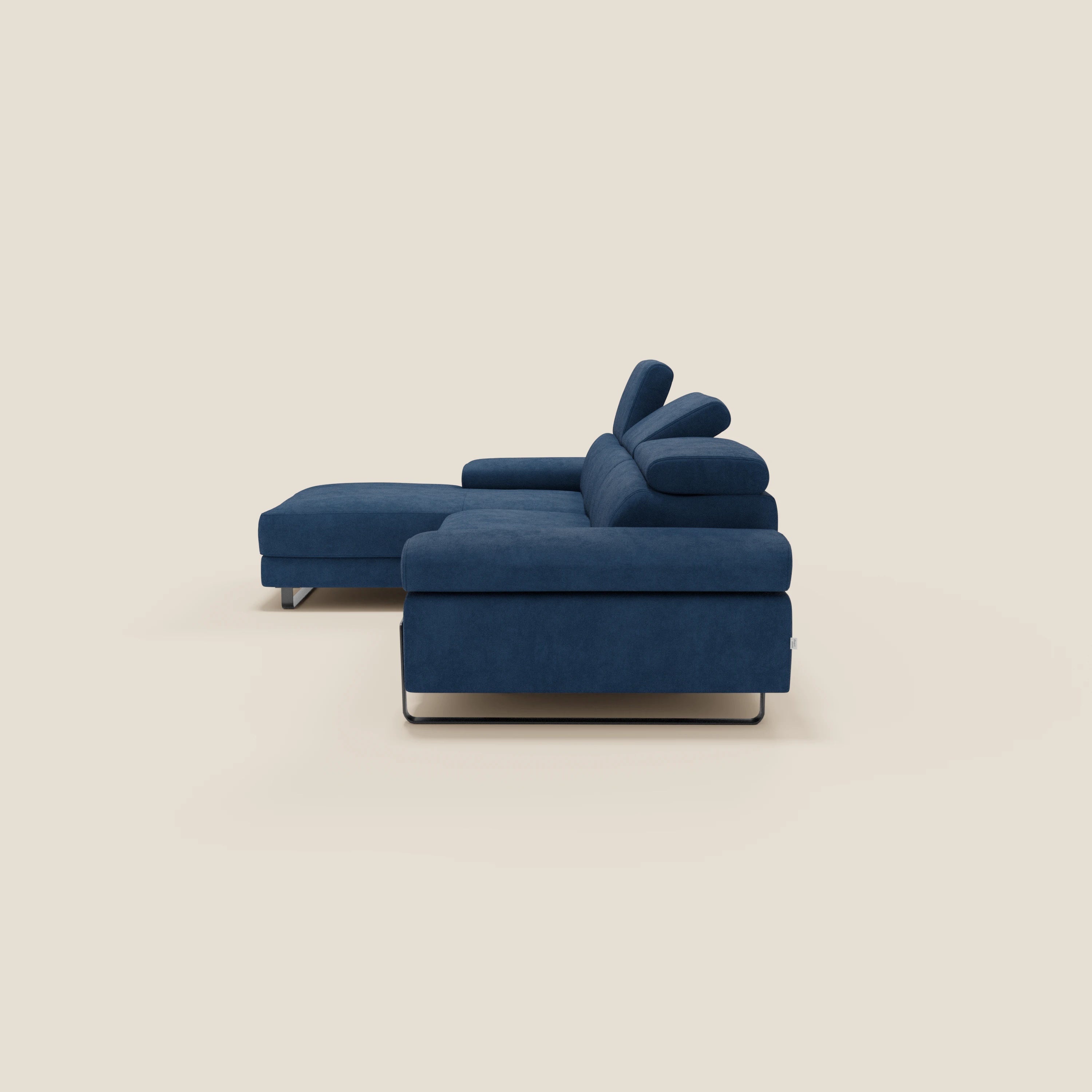 Il divano angolare estraibile Zayana di Divani.Store è caratterizzato da braccioli e poggiatesta reclinabili, tessuto idrorepellente T02 blu, gambe in metallo e design a L, su sfondo beige.