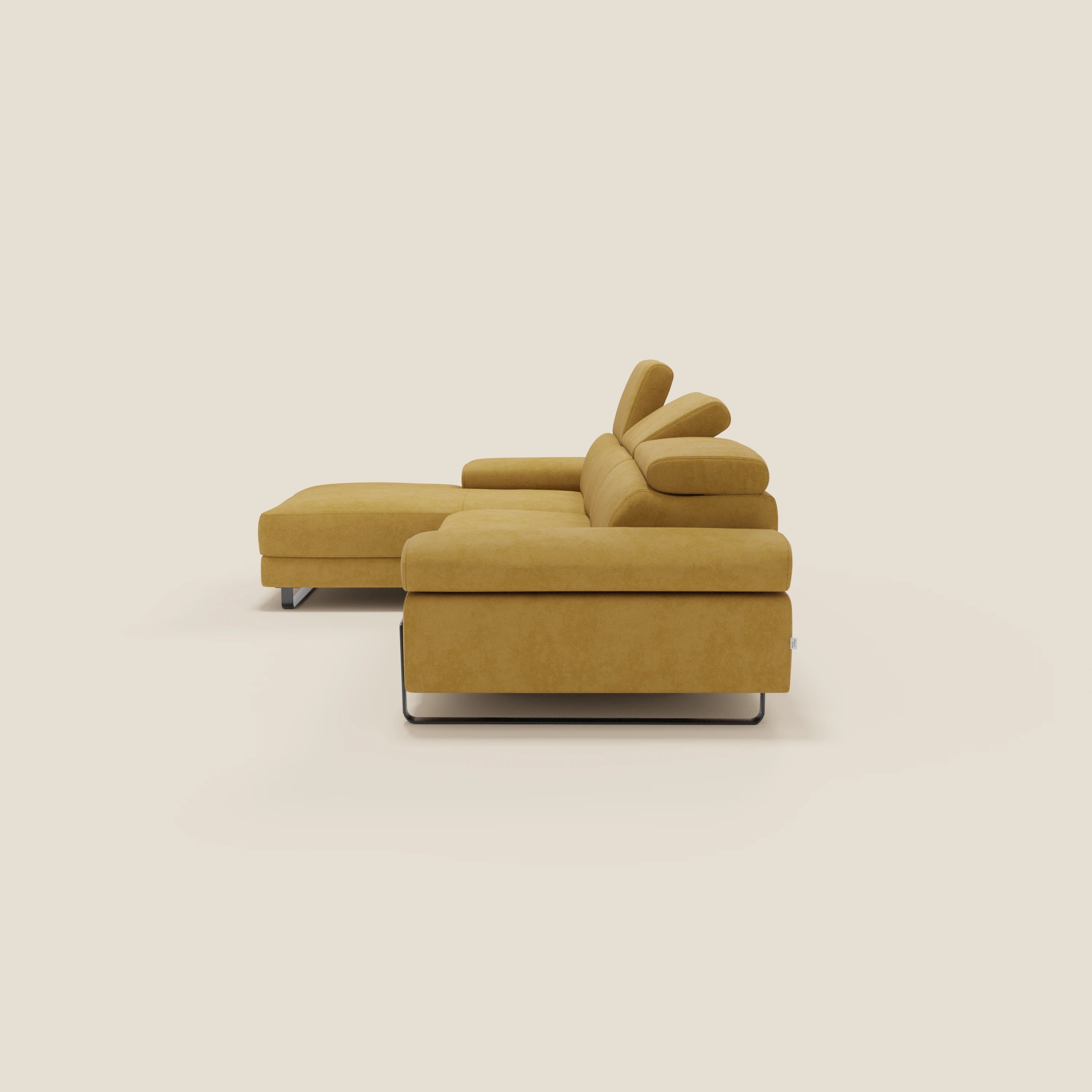 Il divano angolare estraibile Zayana di Divani.Store in tessuto impermeabile T02 giallo è caratterizzato da braccioli e poggiatesta reclinabili, da una chaise longue sinistra e da eleganti gambe in metallo, raffigurate di profilo su uno sfondo bianco sporco.