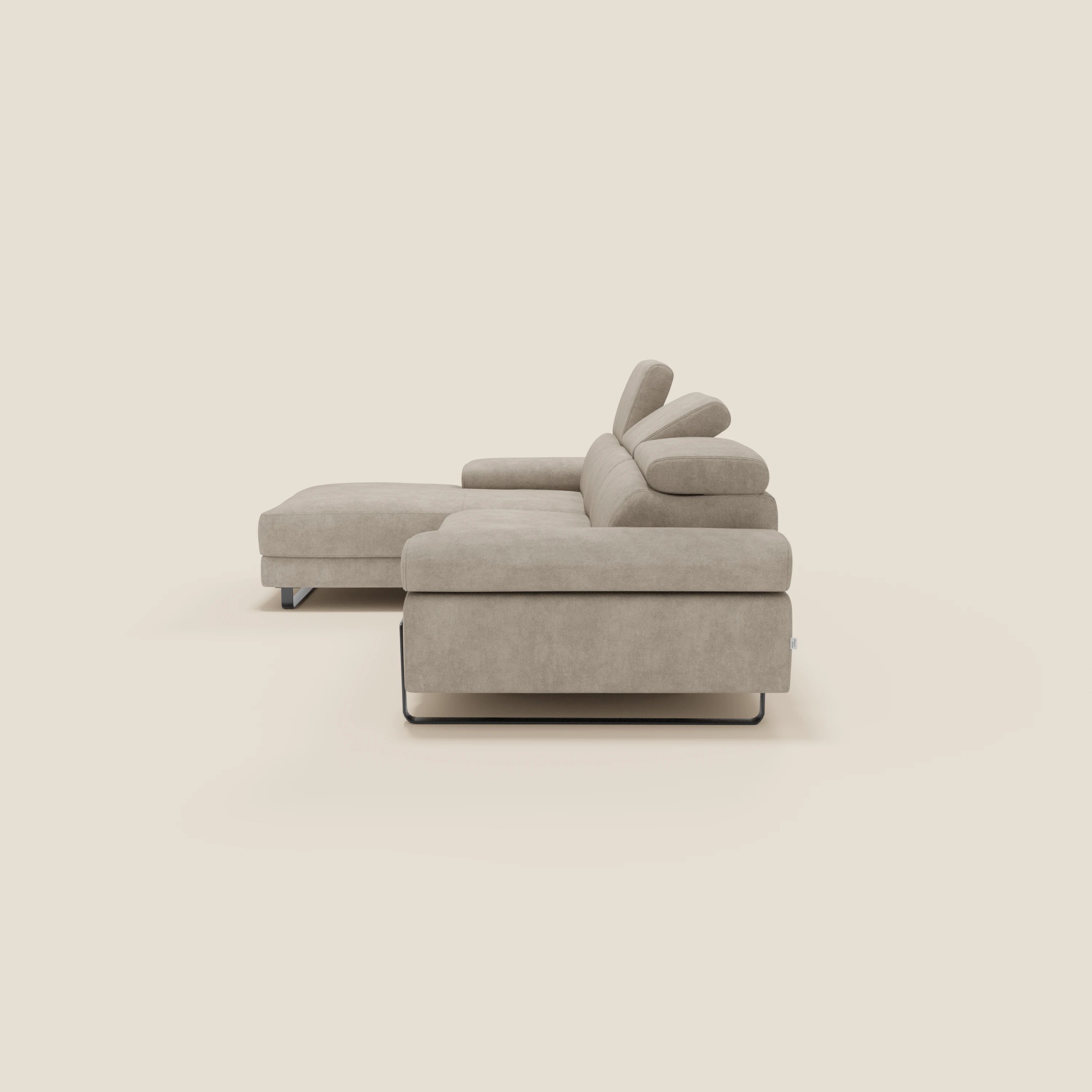 Zayana Divano angolare estraibile di Divani.Store in tessuto impermeabile panna T02 è dotato di braccioli e poggiatesta reclinabili per garantire comfort e stile. Presentato lateralmente su uno sfondo crema chiaro, questo moderno divano componibile beige offre una facile manutenzione.