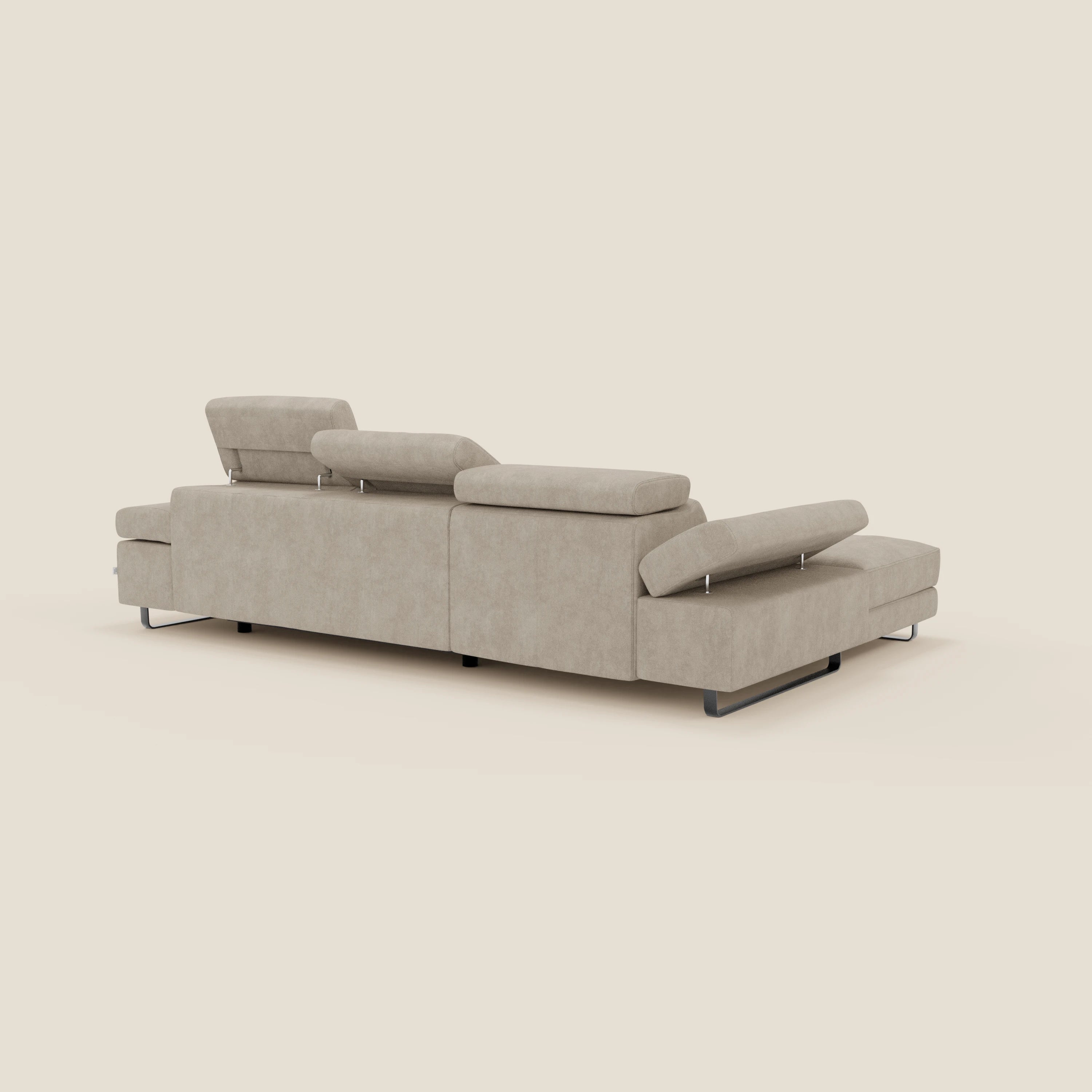 Il divano angolare estraibile Zayana di Divani.Store, presentato in tessuto T02 panna impermeabile, è caratterizzato da braccioli e poggiatesta reclinabili e da moderne gambe in metallo, esposte su un semplice sfondo bianco sporco.