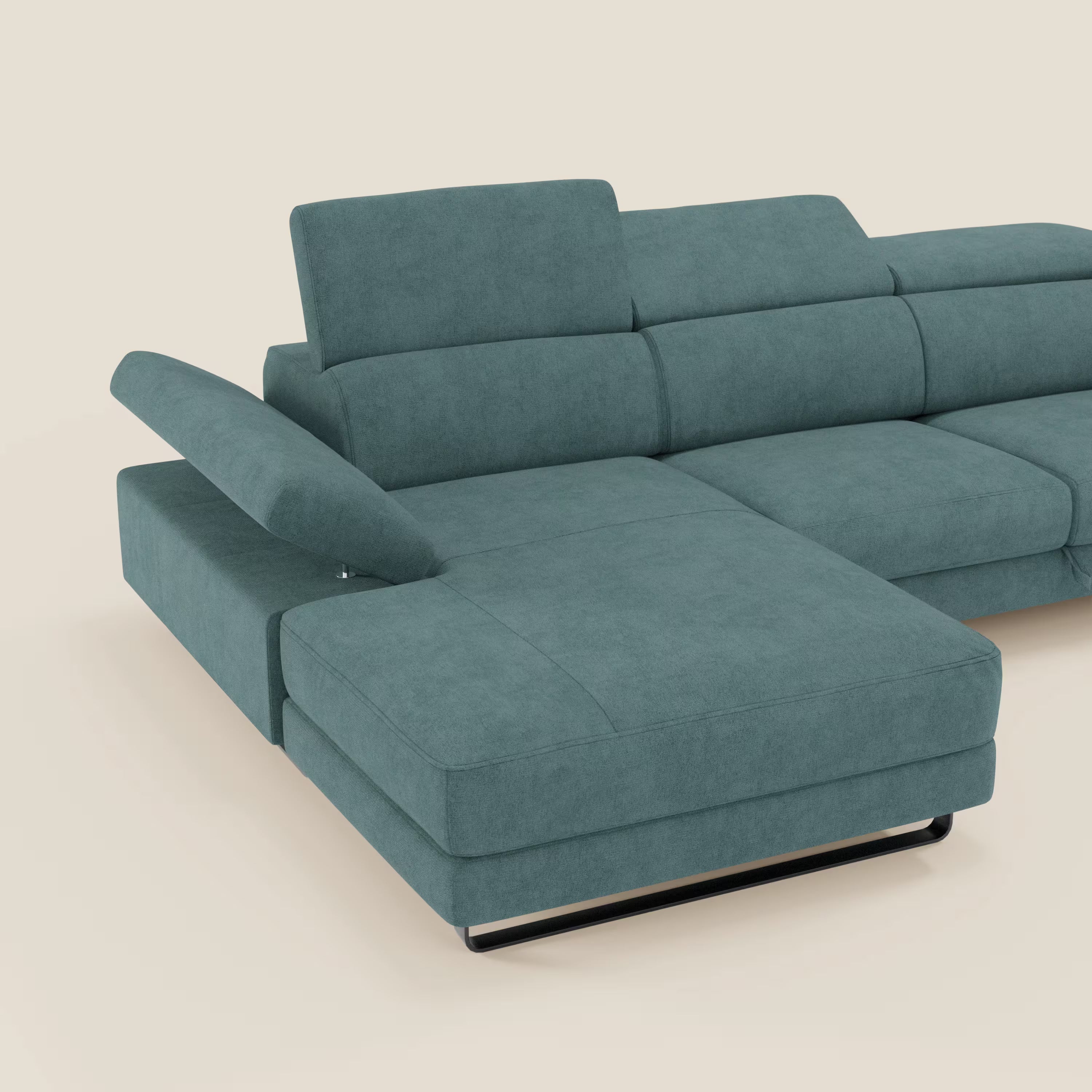 Il divano angolare estraibile Zayana di Divani.Store in T02 petrolio è caratterizzato da braccioli e poggiatesta reclinabili, sedute ampie e morbide e tessuto impermeabile, il tutto su un semplice sfondo beige.