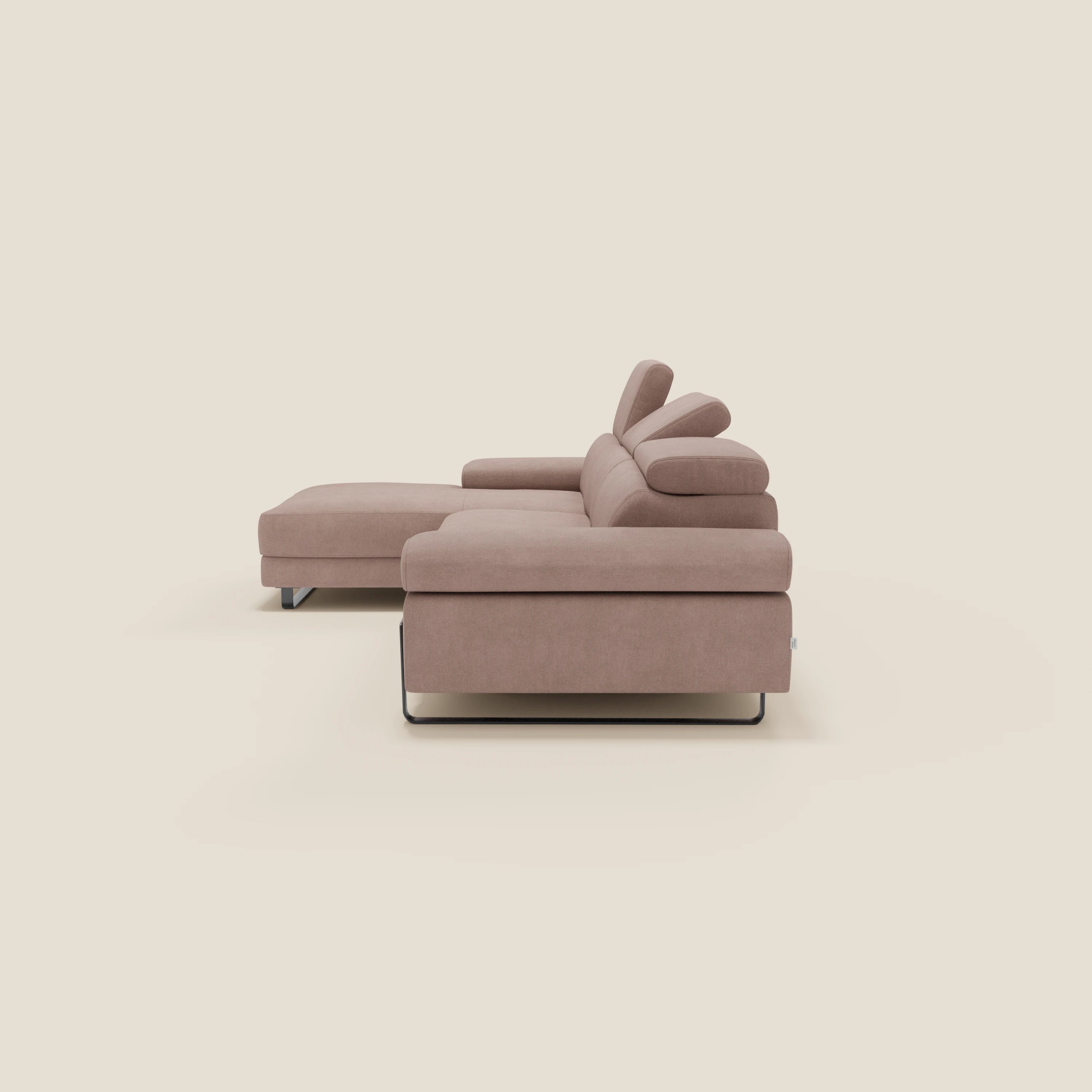 Il divano angolare estraibile Zayana di Divani.Store, nel modello T02 rosa, è caratterizzato da braccioli e poggiatesta reclinabili, linee pulite, chaise lounge a sinistra, gambe in metallo e sfondo beige chiaro.