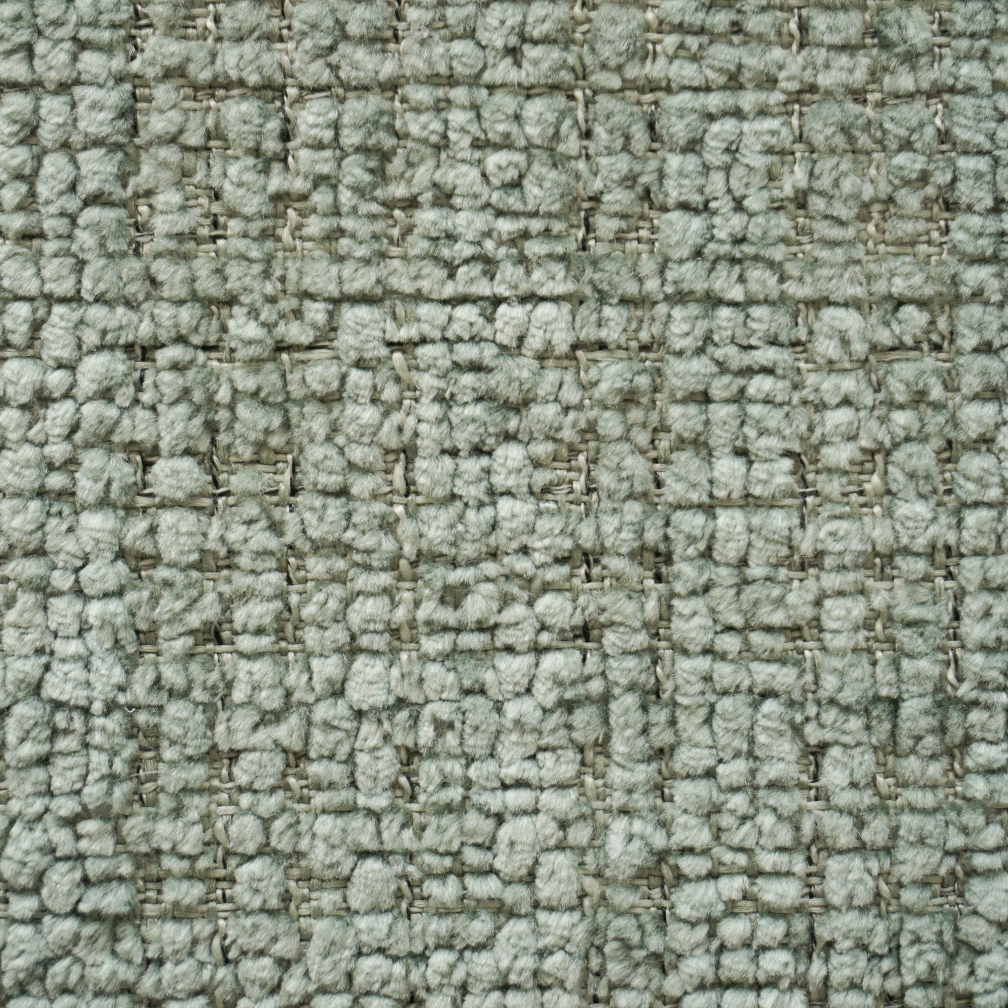 Primo piano di Personalizzazione in T28 di Divani.Store: un tappeto grigio chiaro, con un sottile motivo a griglia simile a un plaid. Il tessuto, morbido e uniforme, presenta asole visibili e fili strettamente intrecciati per un look neutro.