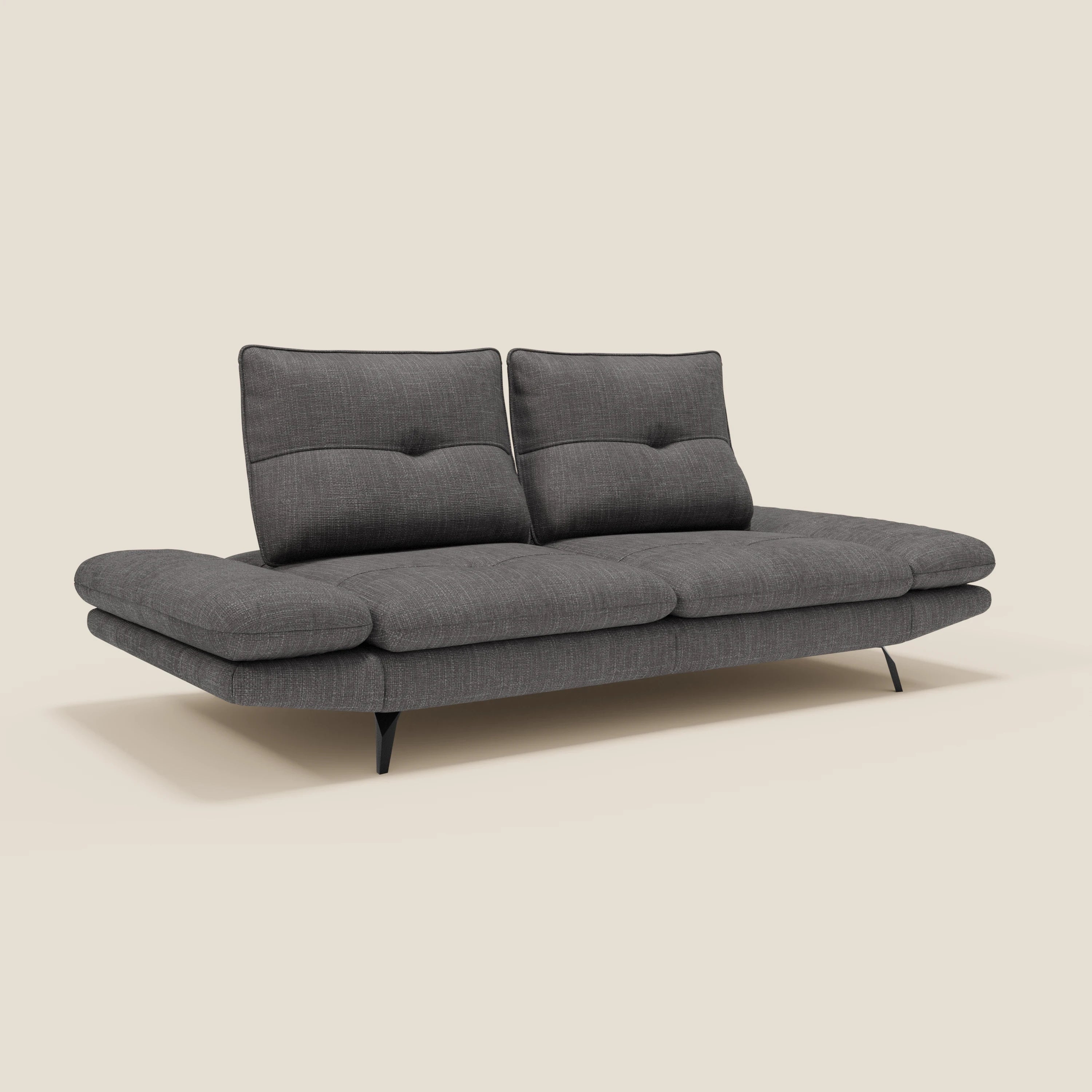 Il divano Ardex Divano 3 posti di Divani.Store in T06 antracite è caratterizzato da schienali traslanti, braccioli regolabili, due morbidi cuscini di schienale ed eleganti gambe in metallo nero. Il divano moderno è inserito in un semplice sfondo beige chiaro.