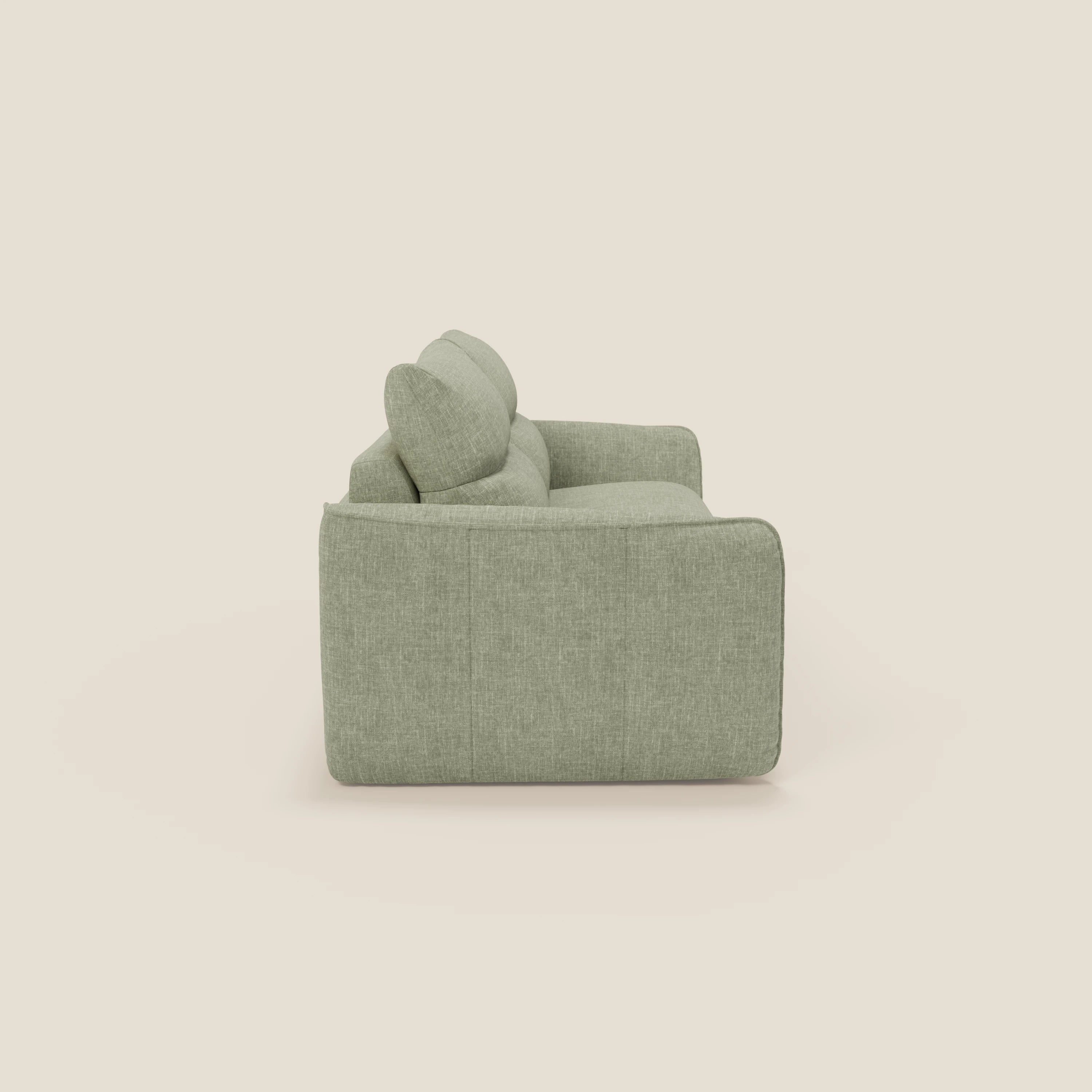 Vista laterale di Divani.Store Elios divano letto con morbidi cuscini spalliera in tessuto smacchiabile T24 verde salvia, con cuscini morbidi, bordi arrotondati e tessuto facile da pulire, su sfondo beige.
