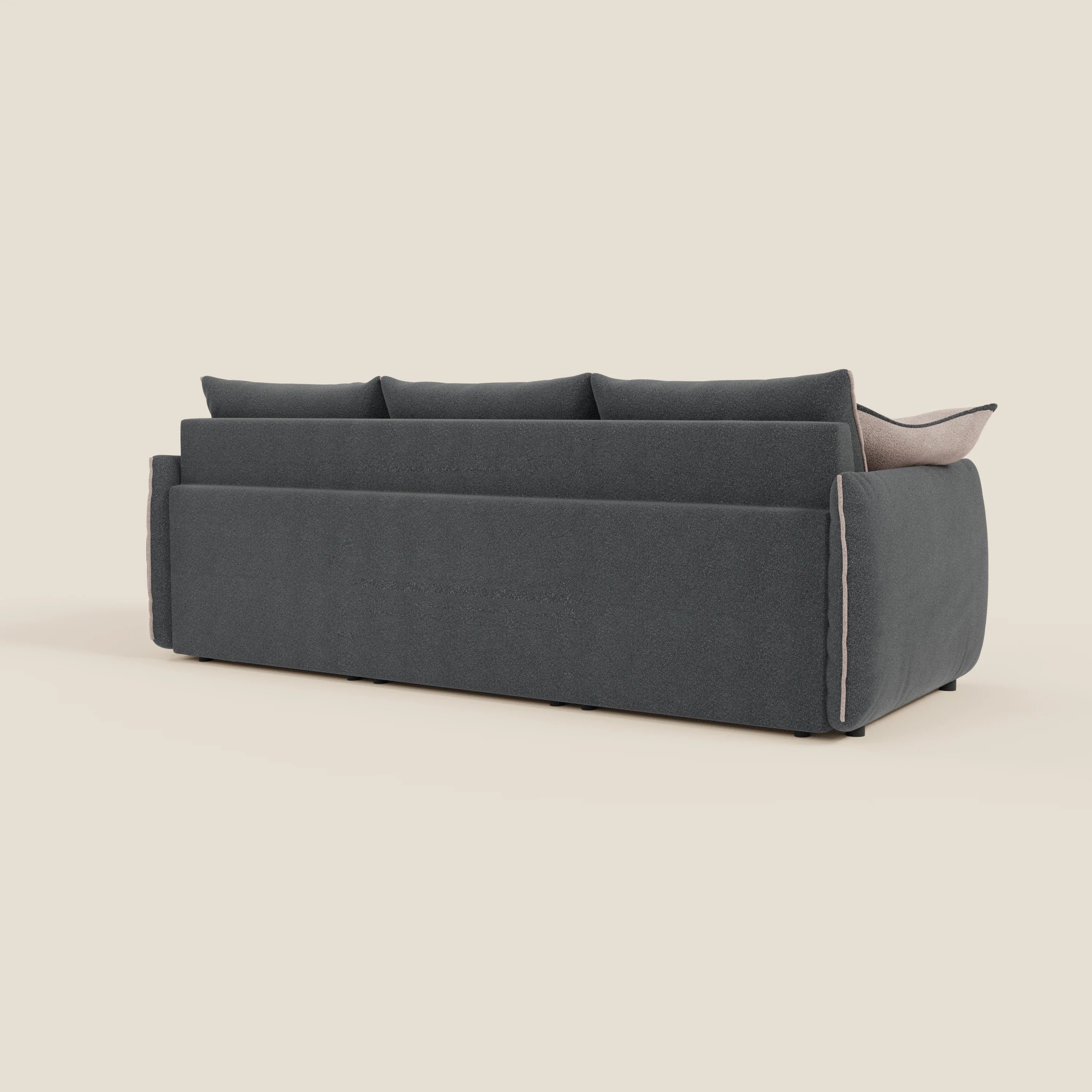 Il divano Flexar con 3 sedute allungabili di Divani.Store, visto di schiena e di lato, è caratterizzato da un design squadrato in bouclé grigio scuro T07 antracite con tre cuscini di schienale, bordi morbidi e arrotondati e profili beige su uno sfondo beige chiaro.