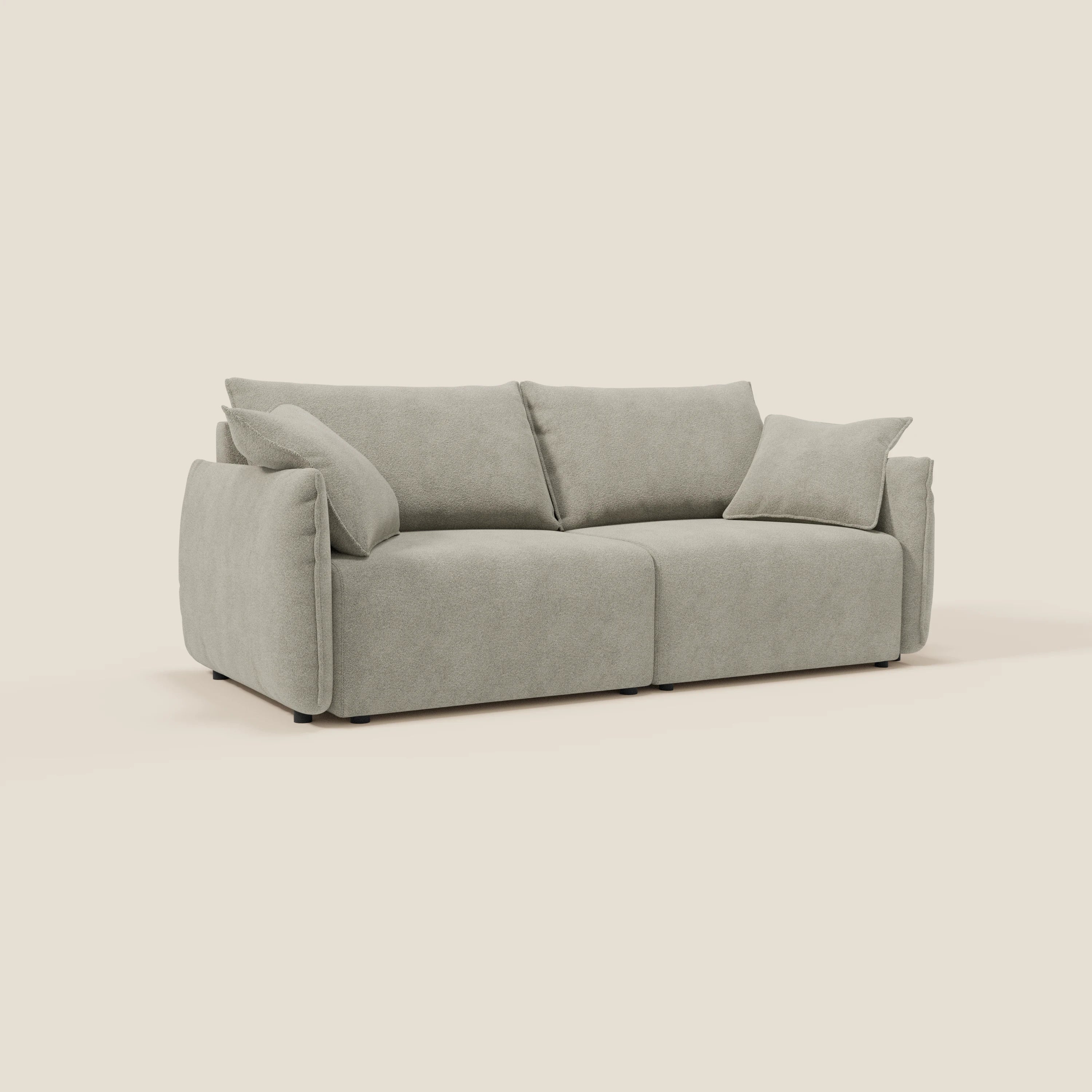 Il divano Flexar con sedute allungabili e schienale in piuma, in morbido bouclé impermeabile T07 beige di Divani.Store, è caratterizzato da ampi braccioli, due grandi cuscini per la seduta e lo schienale e un cuscino coordinato su sfondo beige.