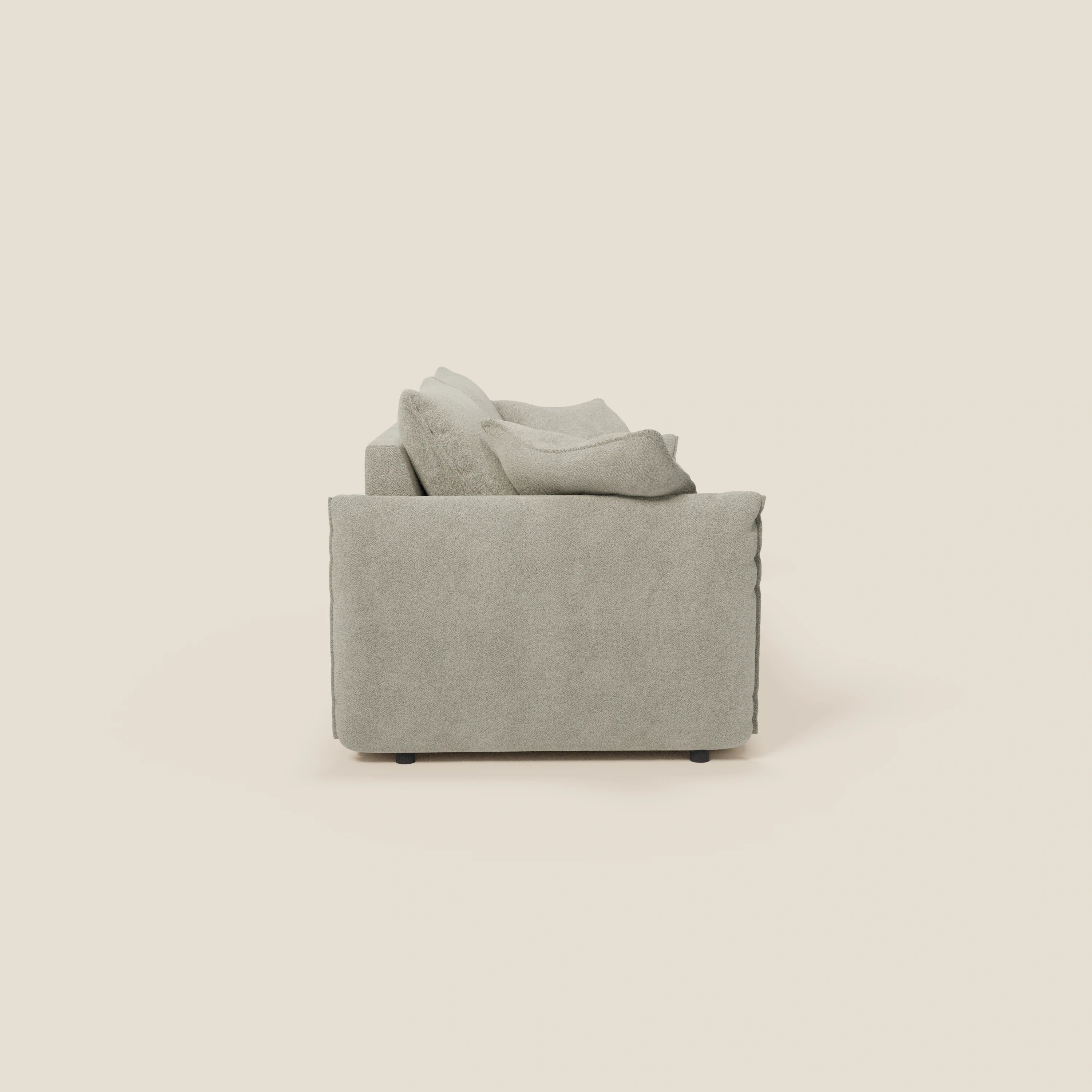 Un moderno divano Flexar con sedute allungabili e schienale in piuma di Divani.Store, presentato lateralmente con una forma squadrata e cuscini in piuma in morbido bouclé impermeabile T07 beige su sfondo bianco sporco.