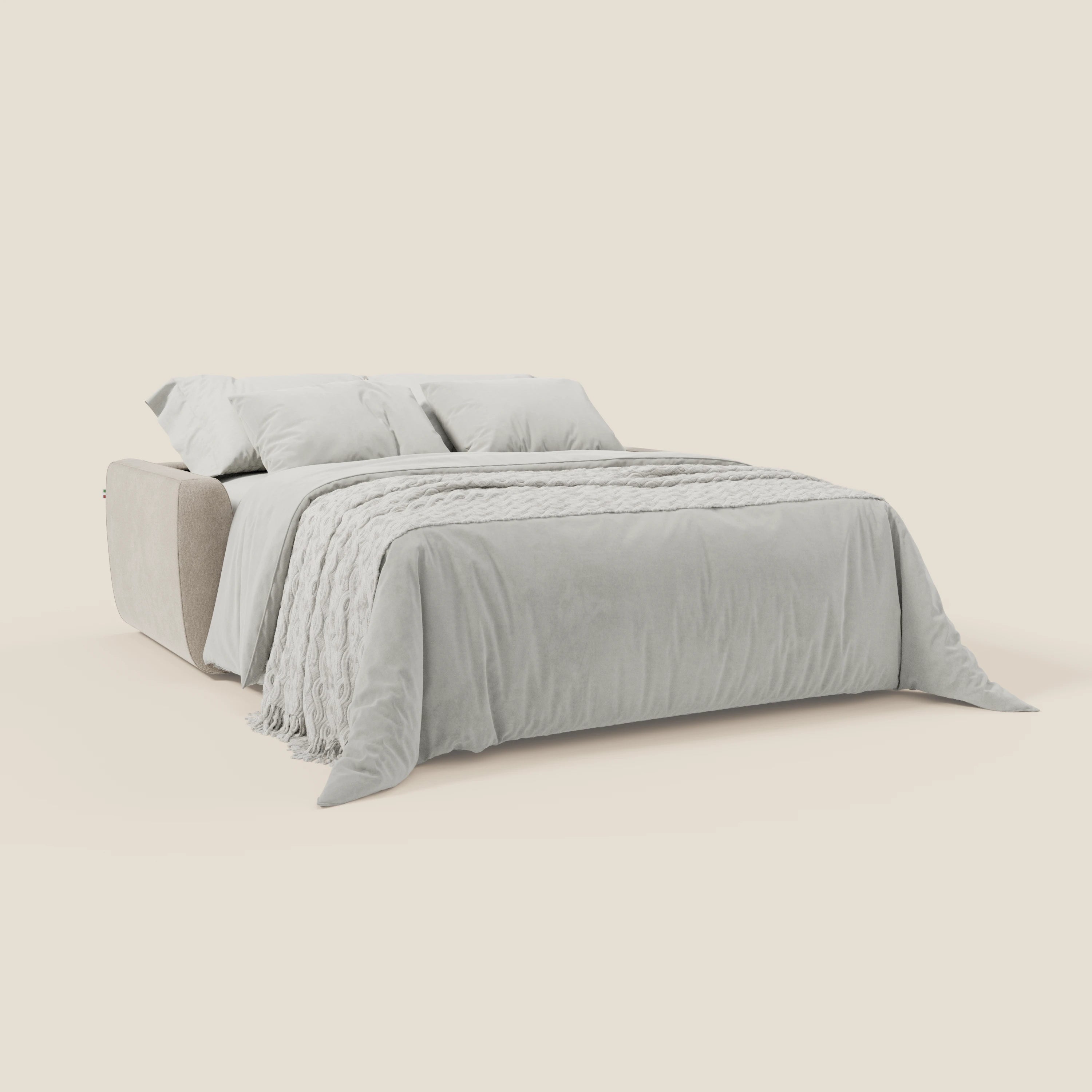 Il divano letto sfoderabile Leonida di Divani.Store, in tessuto smacchiabile T23 panna con materasso H18 cm e cuscino contenitore, è dotato di due cuscini, di un copriletto con frange e di un piumino coordinato in toni neutri e chiari su sfondo crema.