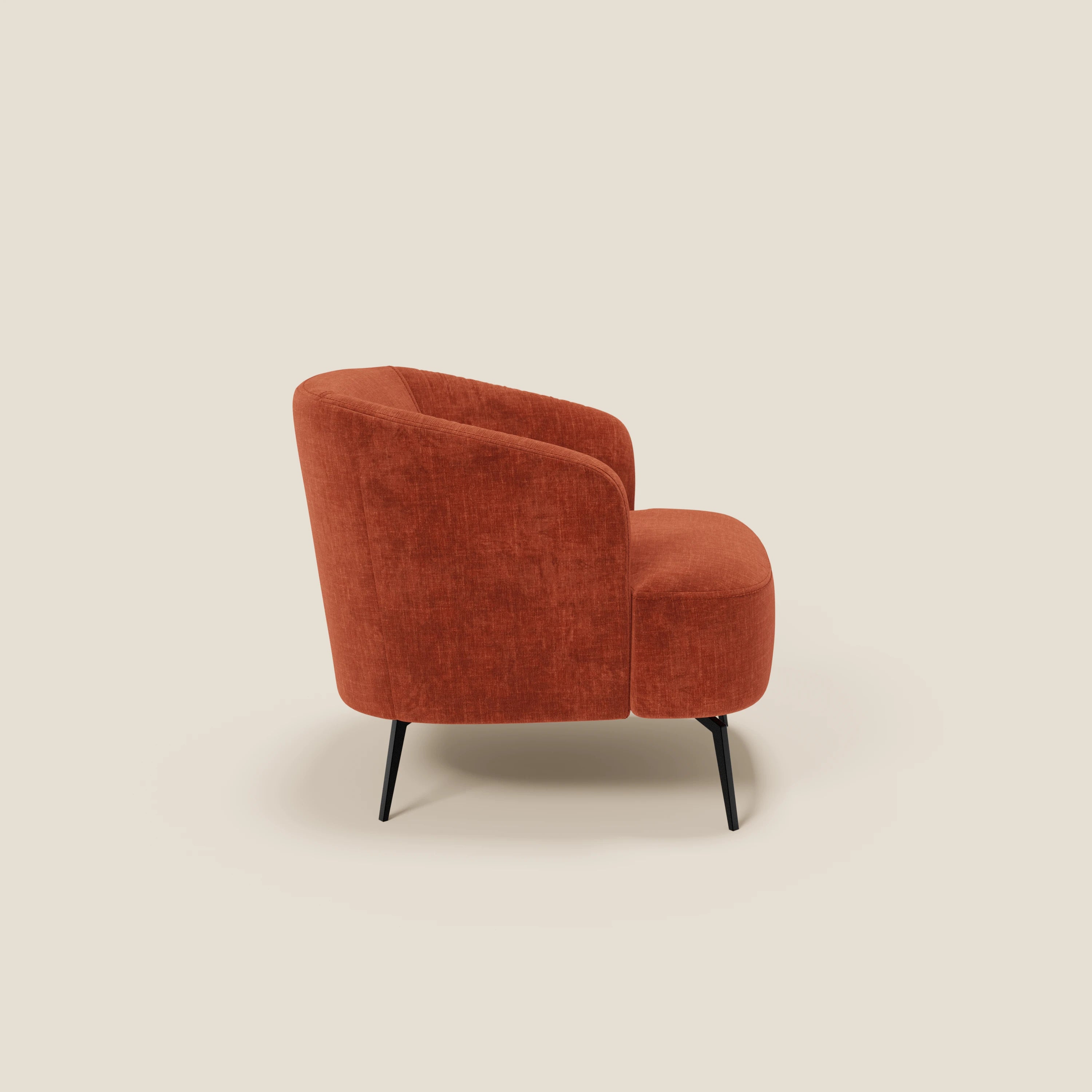 La poltroncina Renoa dall'eleganza moderna di Divani.Store, in tessuto smacchiabile T24 ruggine, è caratterizzata da uno schienale e una seduta arrotondati per un comfort ergonomico, sostenuti da quattro sottili gambe angolate nere su sfondo crema.