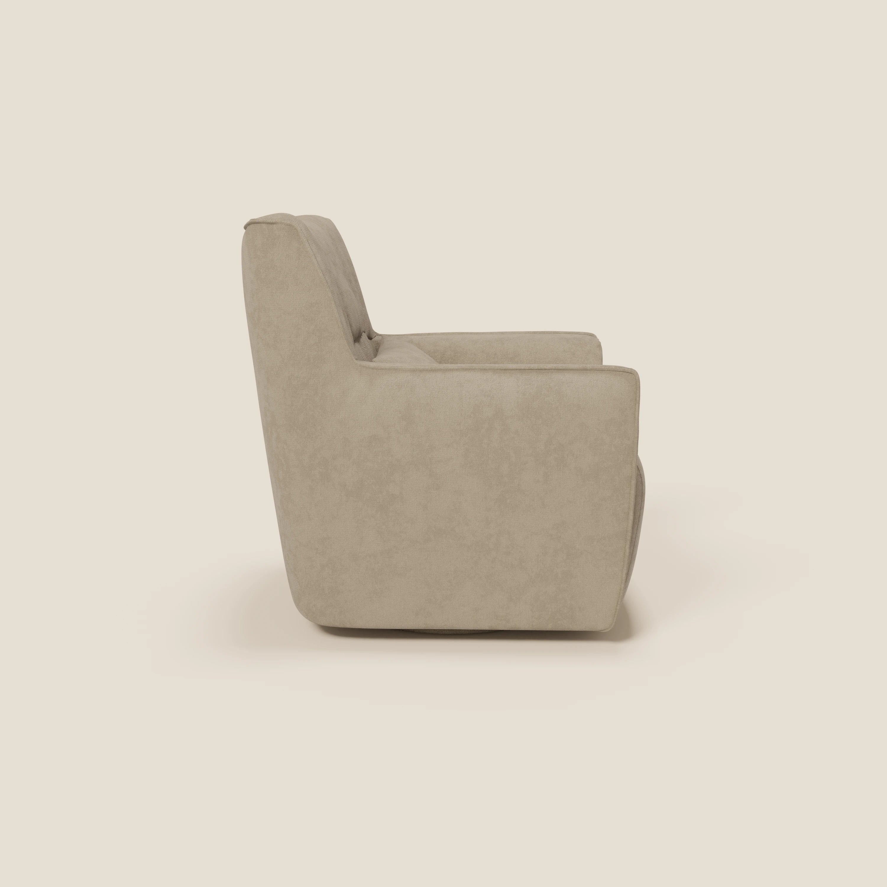 La poltrona girevole Tulla in tessuto impermeabile T02 beige di Divani.Store è presentata di profilo su sfondo beige chiaro, con schienale alto, ampia seduta, braccioli spessi e design minimalista per uno stile confortevole.