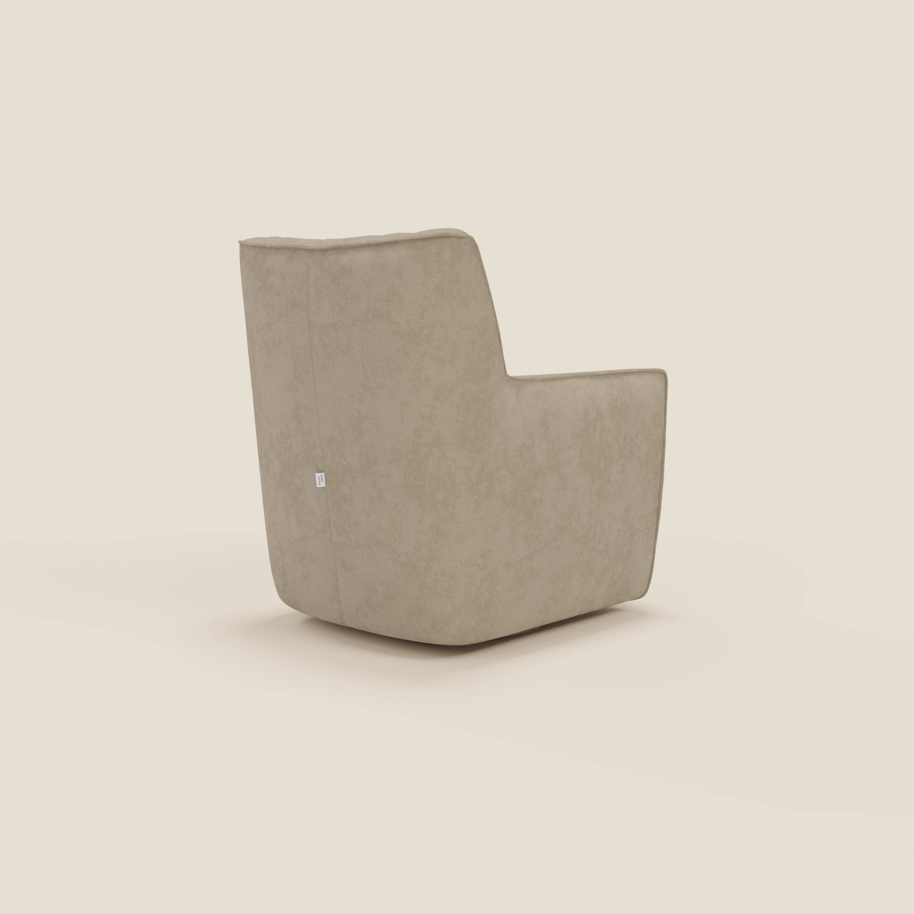 La poltrona girevole Tulla in tessuto impermeabile T02 beige di Divani.Store è caratterizzata da un design moderno e squadrato, con braccioli bassi e schienale squadrato, che si presenta ad angolo su uno sfondo bianco sporco. Una piccola targhetta in tessuto sottolinea il lato.