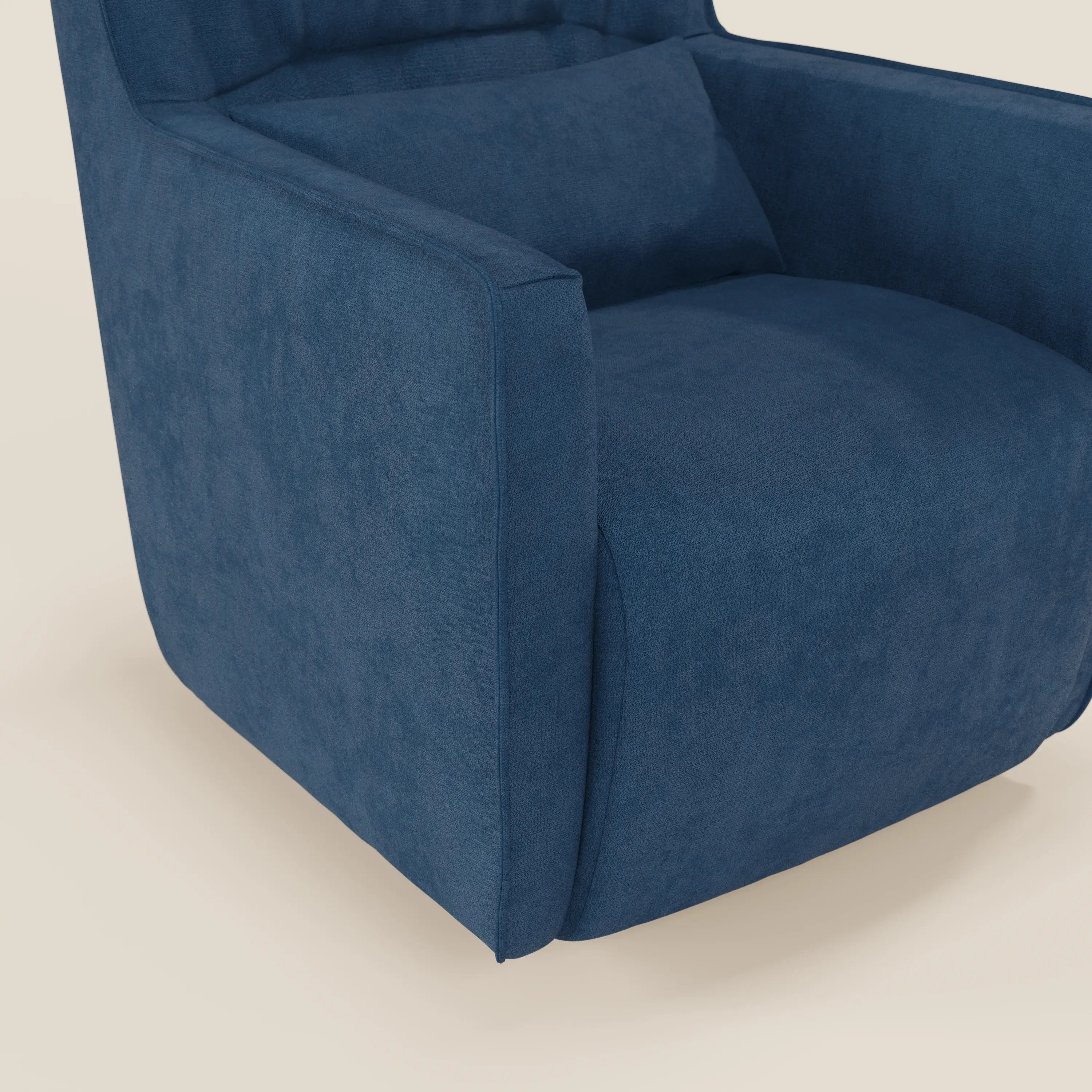 Un primo piano di Divani.Store Tulla Poltrona girevole in tessuto impermeabile T02 blu mostra un bracciolo, l'ampia seduta compatta e un cuscino rettangolare abbinato sullo schienale. La scena è ambientata su uno sfondo bianco sporco.