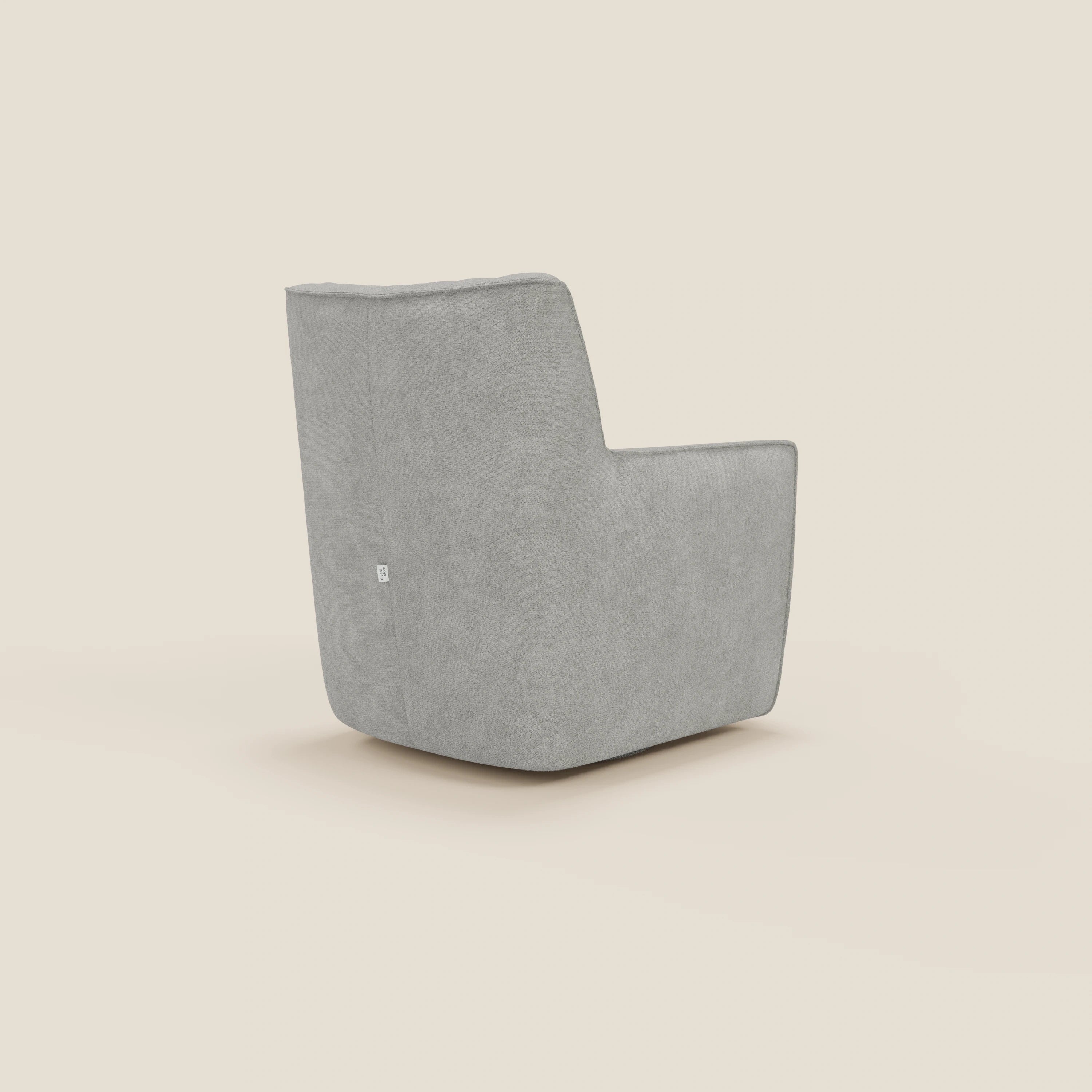 La poltrona girevole Tulla Poltrona girevole in tessuto impermeabile T02 grigio chiaro di Divani.Store è una poltrona girevole moderna e minimalista di colore grigio, con texture in tessuto morbido, silhouette squadrata, braccioli piatti e schienale leggermente reclinato su uno sfondo bianco sporco.