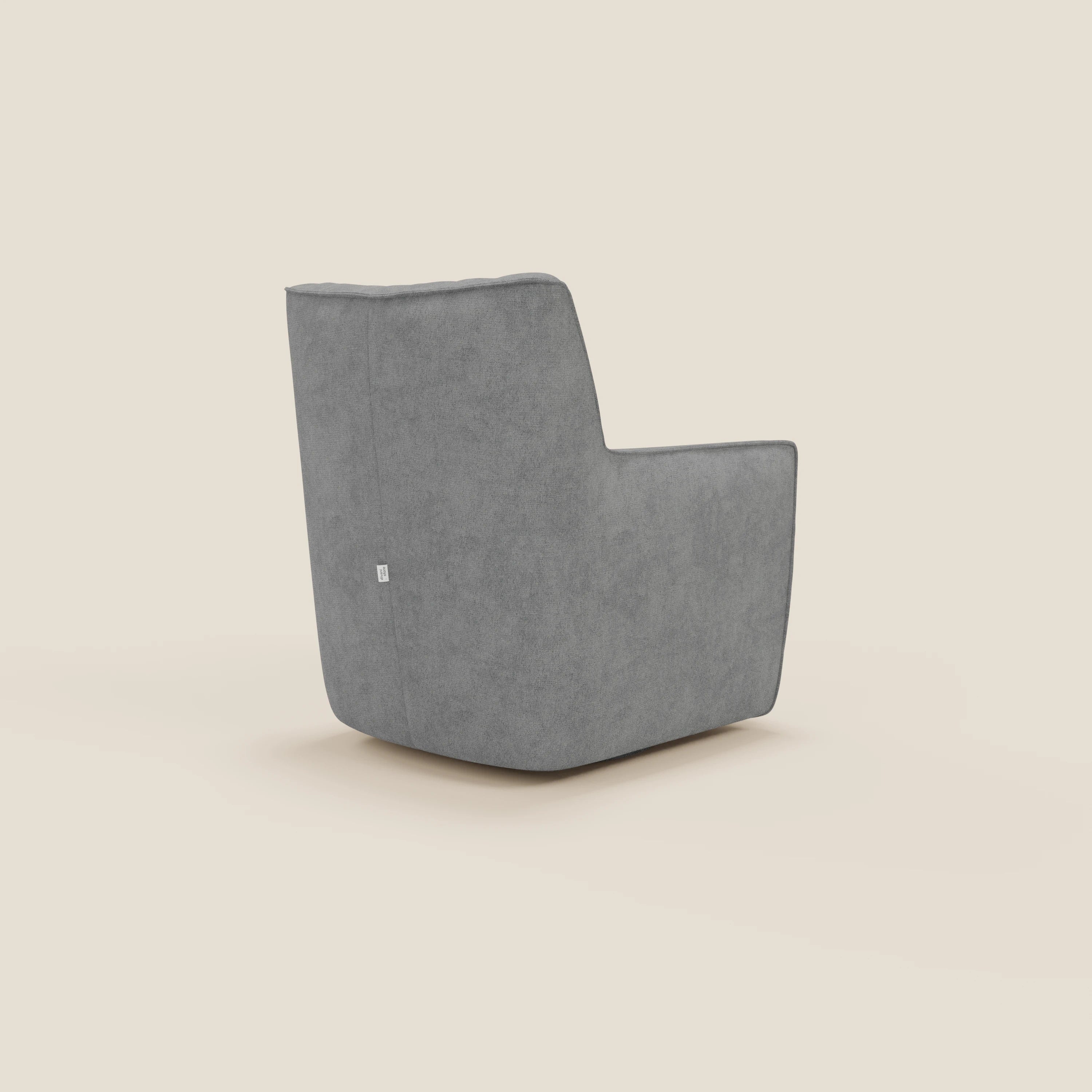 La poltrona girevole Tulla in tessuto impermeabile T02 grigio di Divani.Store, vista dal retro in posizione angolata, è caratterizzata da un design moderno e minimalista, da un morbido tessuto grigio, da linee rette, da uno schienale inclinato e da una piccola etichetta laterale.