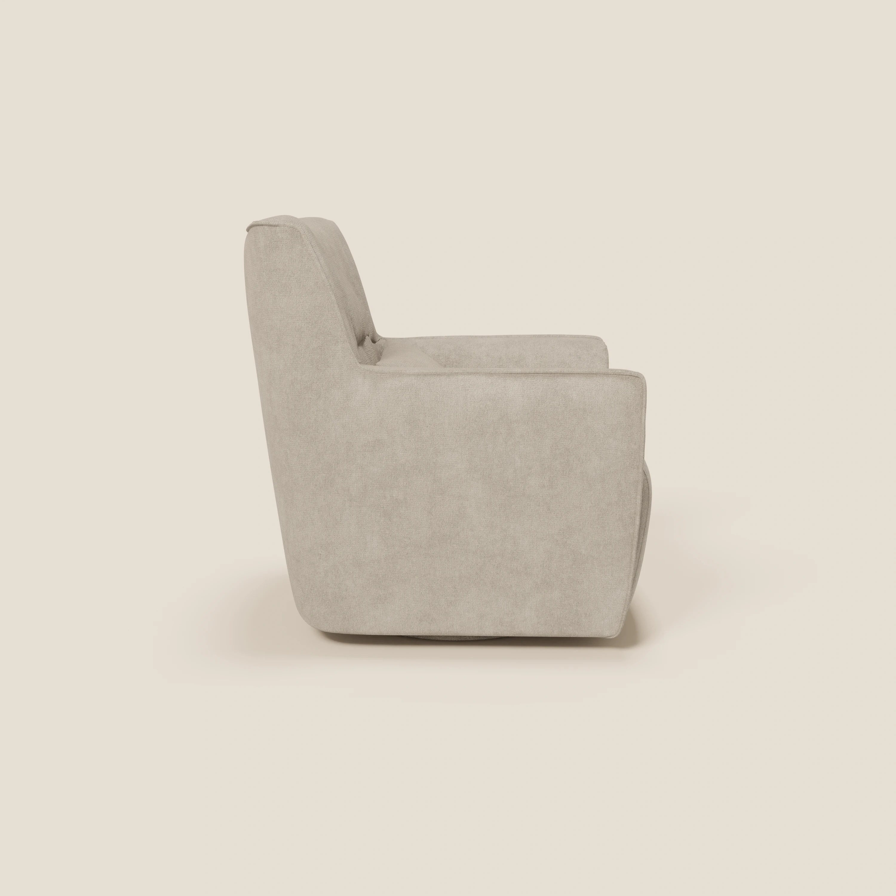 La poltrona girevole Tulla in tessuto impermeabile T02 panna di Divani.Store è presentata lateralmente su sfondo bianco sporco, con una spessa seduta imbottita, uno schienale leggermente reclinato e linee minimaliste senza gambe a vista.
