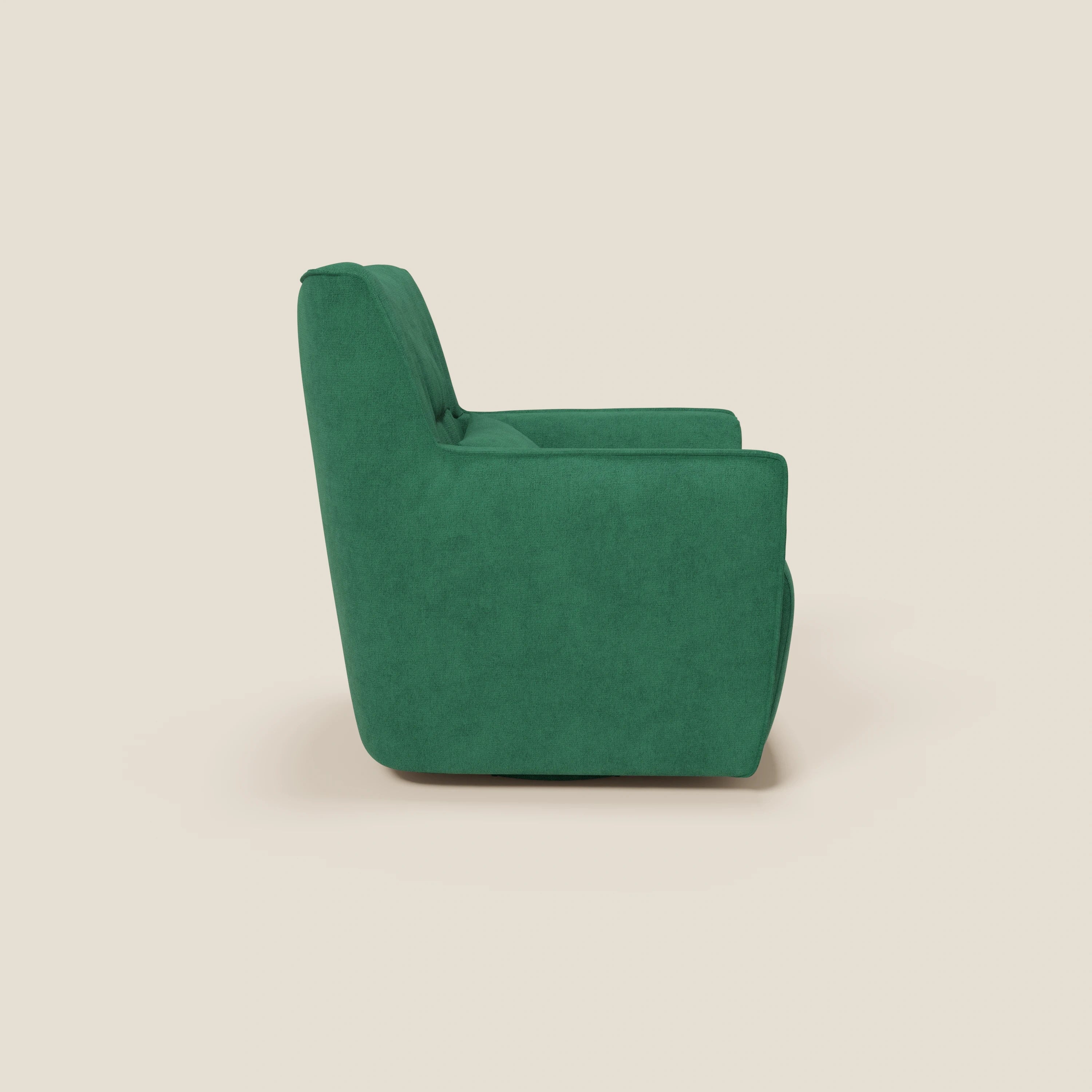 La poltrona girevole Tulla in tessuto impermeabile T02 verde di Divani.Store, con schienale alto, seduta imbottita e braccioli squadrati, è presentata di profilo su uno sfondo beige chiaro per un look moderno e pulito.