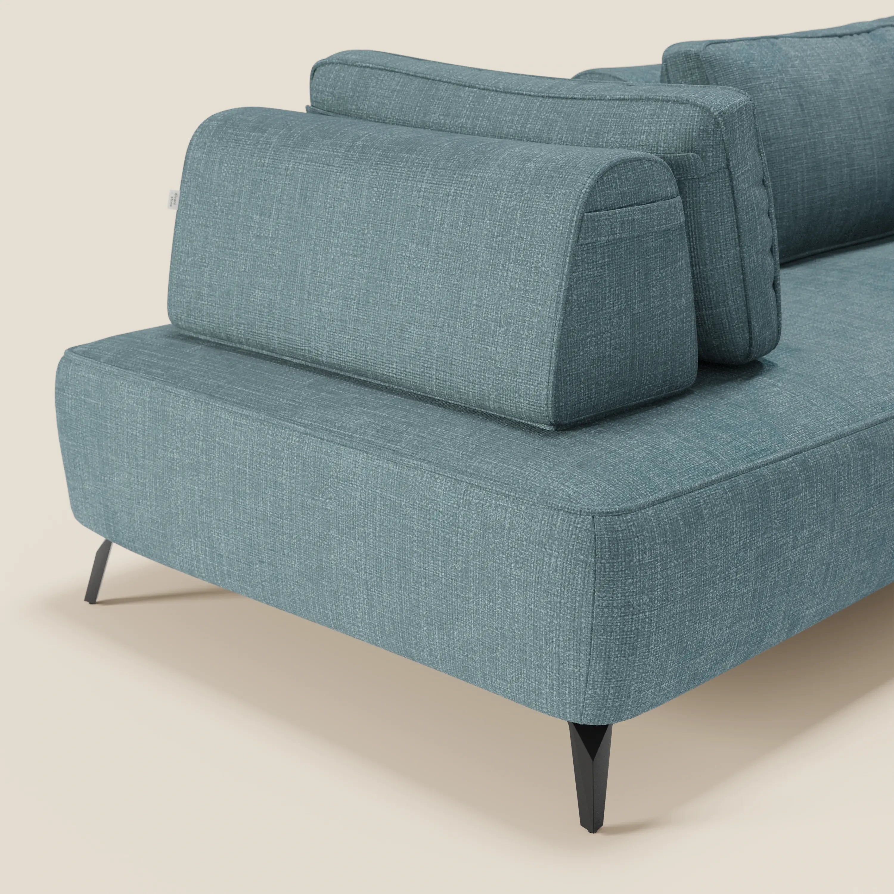 Primo piano del divano modulare Volta con schienali mobili in tessuto ciniglia T06 azzurro di Divani.Store, con schienali mobili in posizione verticale sulla seduta, gambe angolate in metallo nero e sfondo beige chiaro.