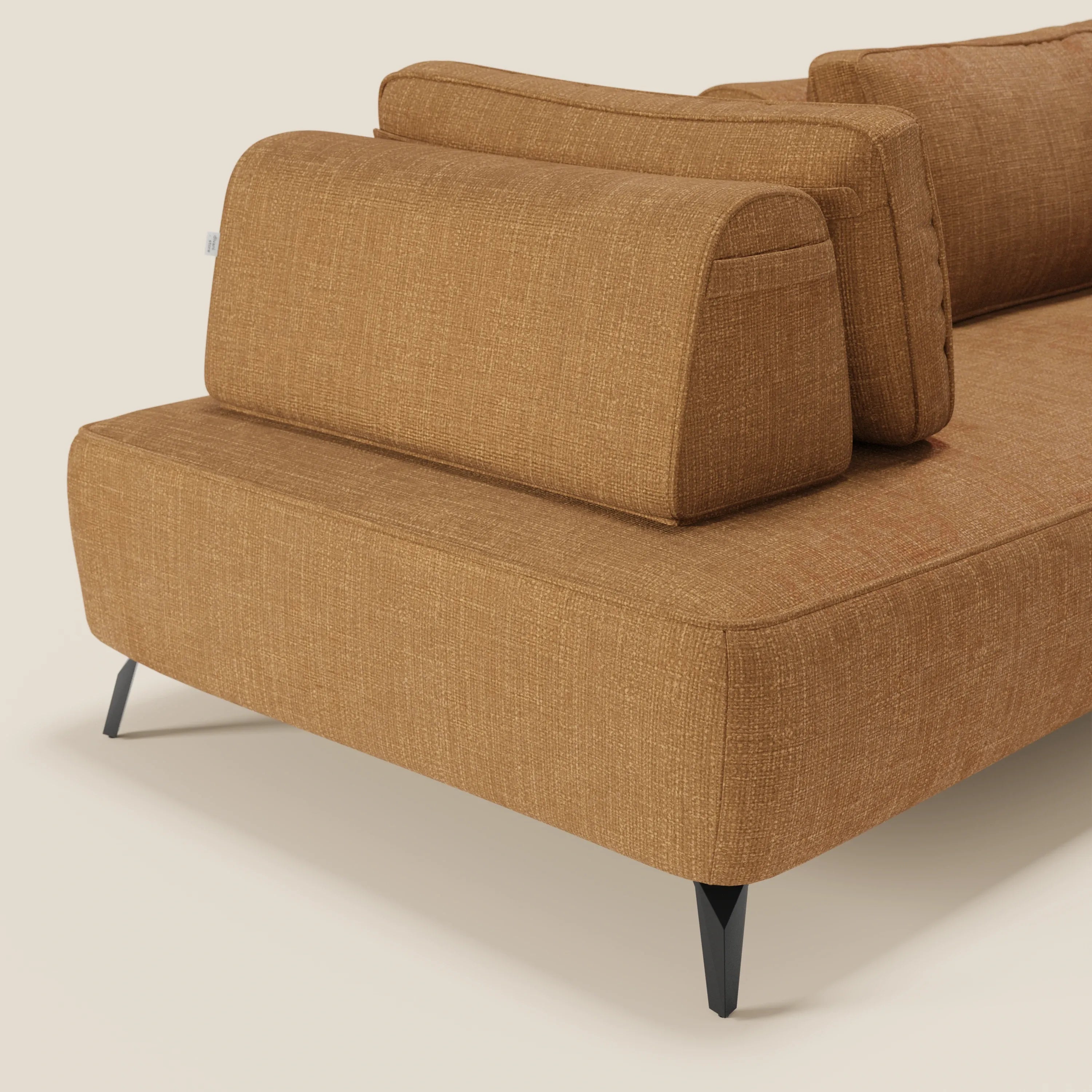 Un primo piano del divano modulare Volta di Divani.Store mette in mostra il raffinato tessuto ciniglia T06 ocra, gli schienali mobili, i cuscini a blocco e le eleganti gambe in metallo nero per un look chic e contemporaneo su uno sfondo beige.