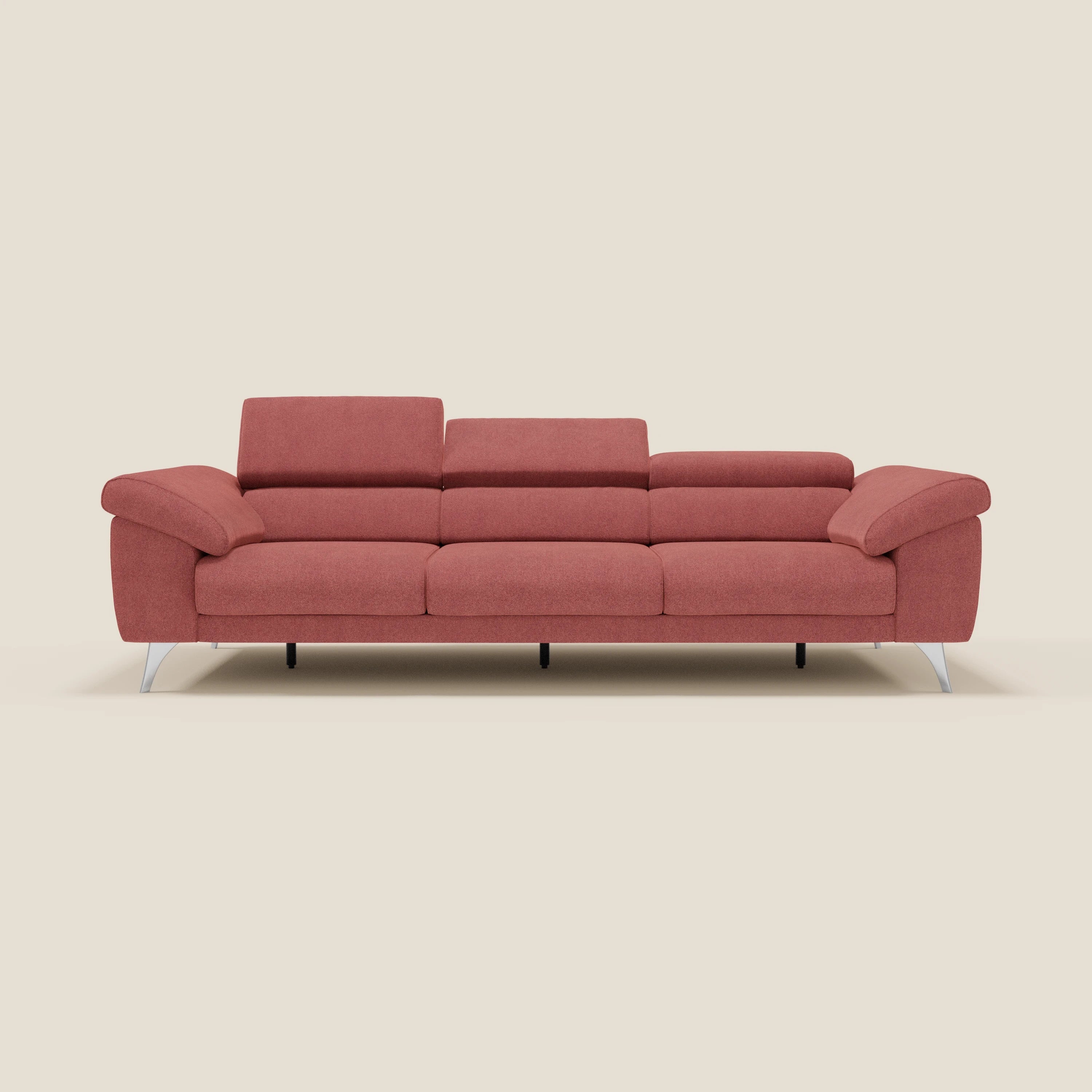 Il divano Donatello di Divani.Store è un moderno 3 posti con sedute allungabili, braccioli contenitore e poggiatesta reclinabili in tessuto smacchiabile T23 rosso ciliegia, gambe in metallo argentato, su sfondo beige chiaro.
