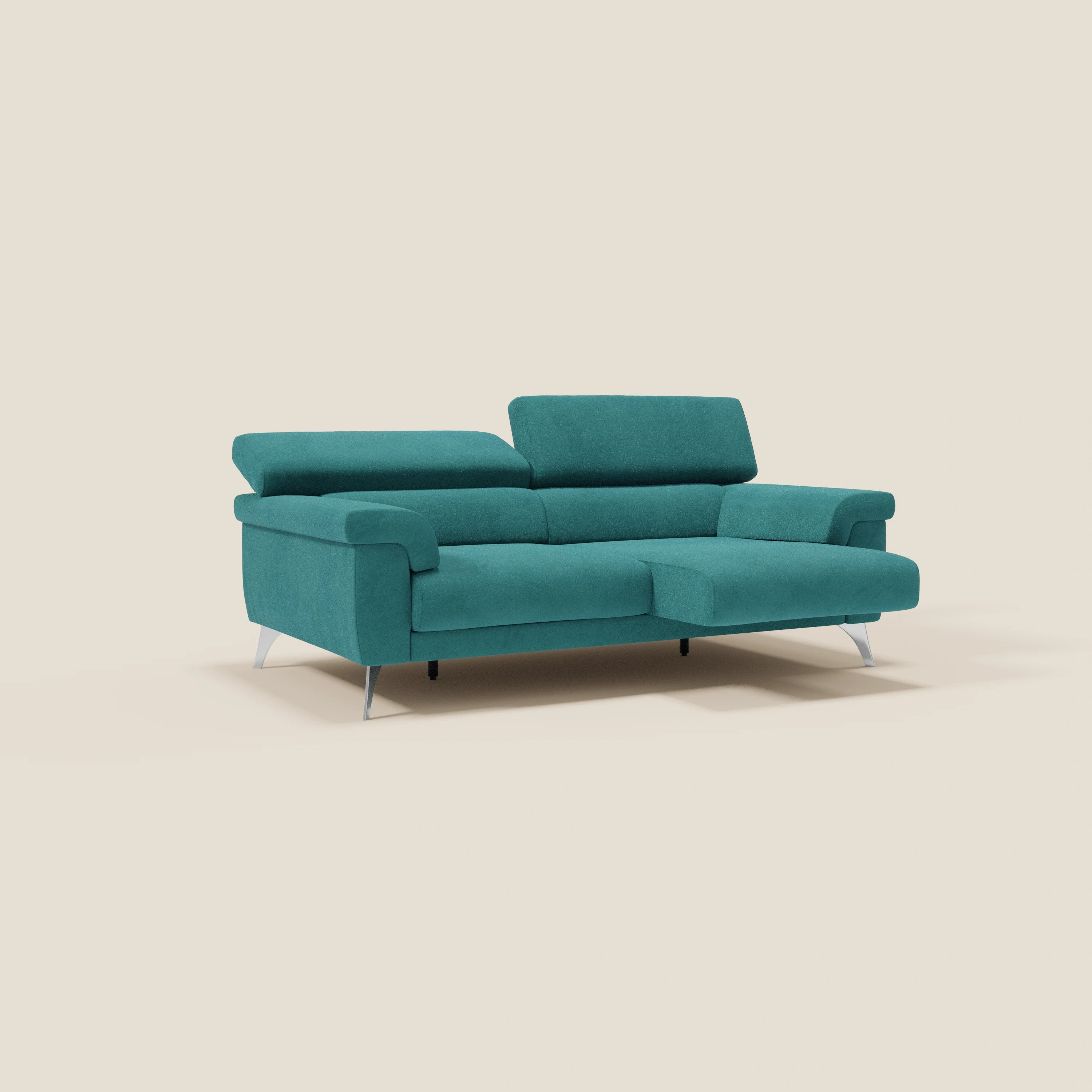 Il divano Raffaello con sedute allungabili e poggiatesta reclinabili in microfibra smacchiabile T11 petrolio di Divani.Store abbina il comfort regolabile a materiali pregiati e a un'eleganza moderna, su uno sfondo beige semplice con eleganti gambe argentate.
