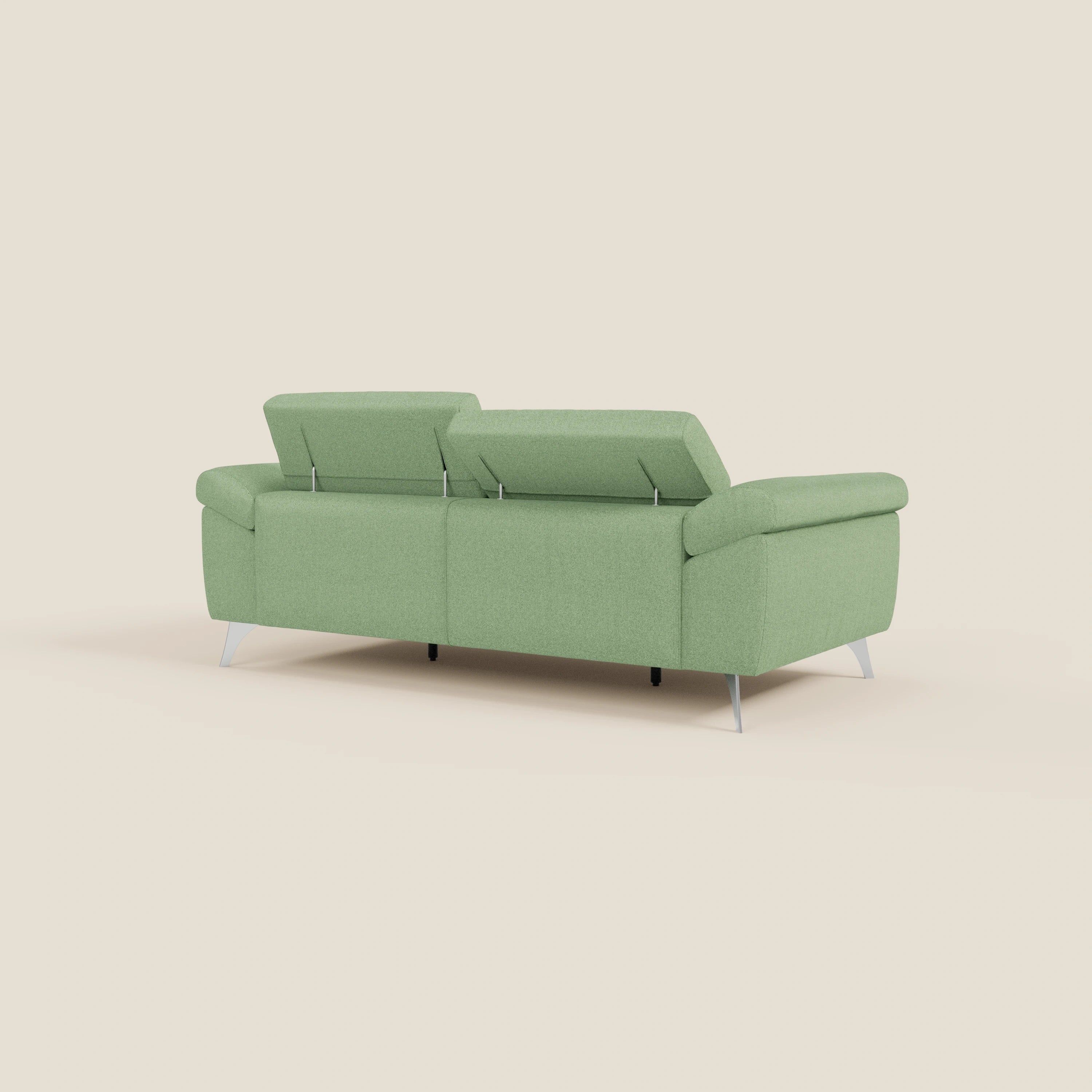 Un divano moderno Donatello di Divani.Store in smacchiabile T23 menta, con gambe in metallo, tre sedute, poggiatesta regolabili e braccioli contenitori, è mostrato dal retro su uno sfondo beige semplice.