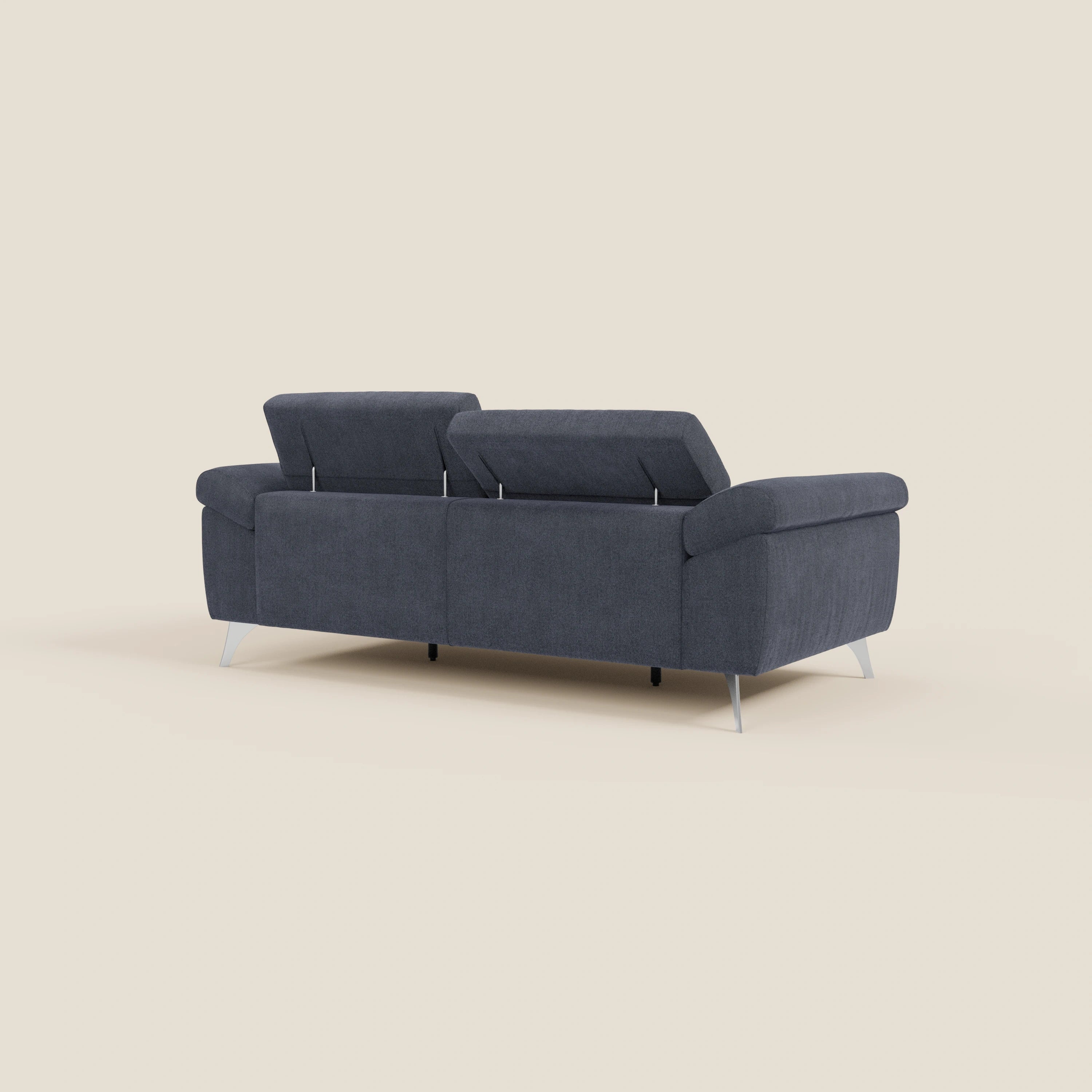 Il divano Donatello di Divani.Store, presentato nella parte posteriore in tessuto smacchiabile T23 blu ardesia, è caratterizzato da braccioli contenitore e due poggiatesta reclinabili rialzati, che spiccano in un ambiente minimalista su uno sfondo beige chiaro.