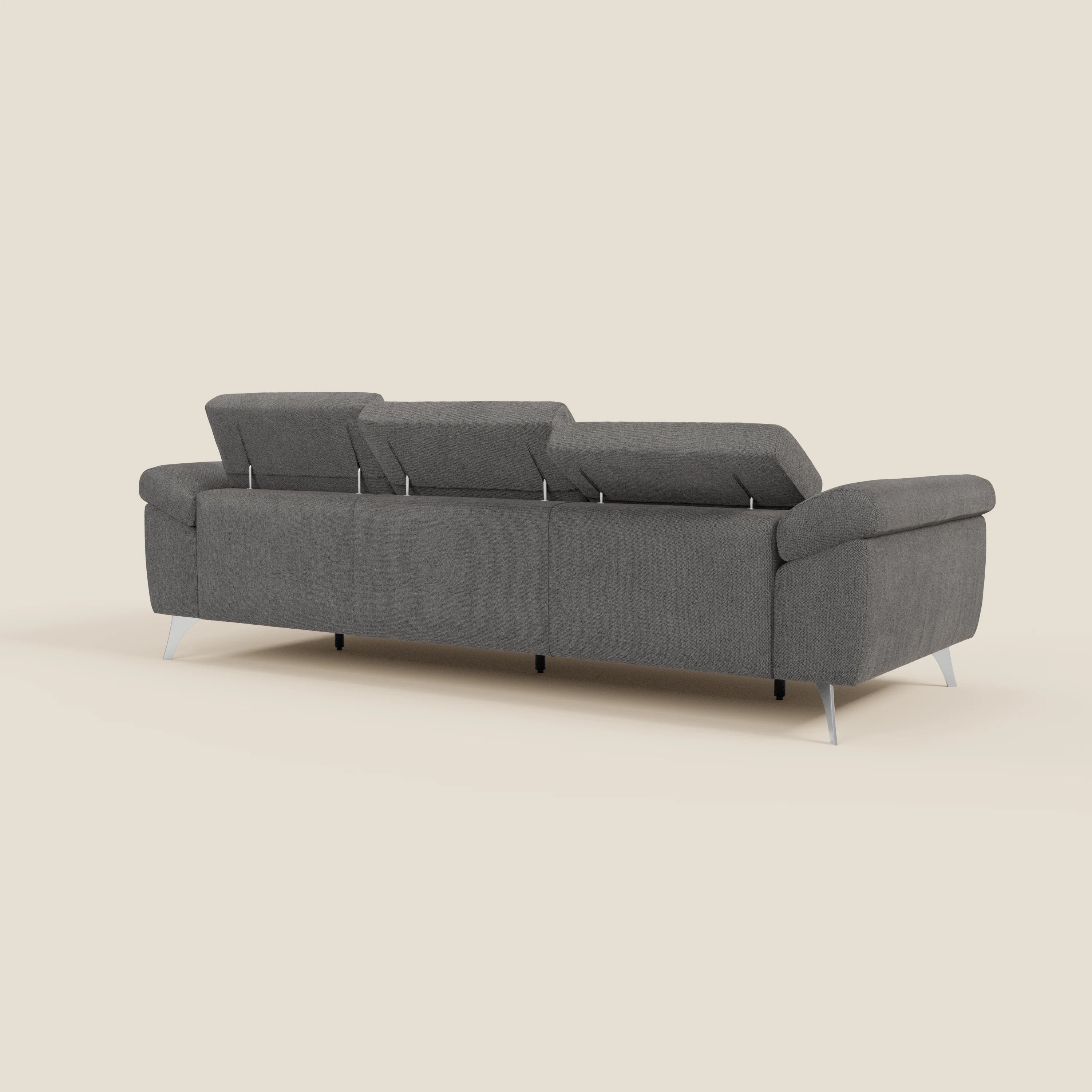 Il divano Donatello di Divani.Store in tessuto smacchiabile T23 antracite è caratterizzato da 3 sedute allungabili, braccioli contenitore e poggiatesta reclinabili, presentati dal retro su sfondo beige per un design contemporaneo e minimalista.