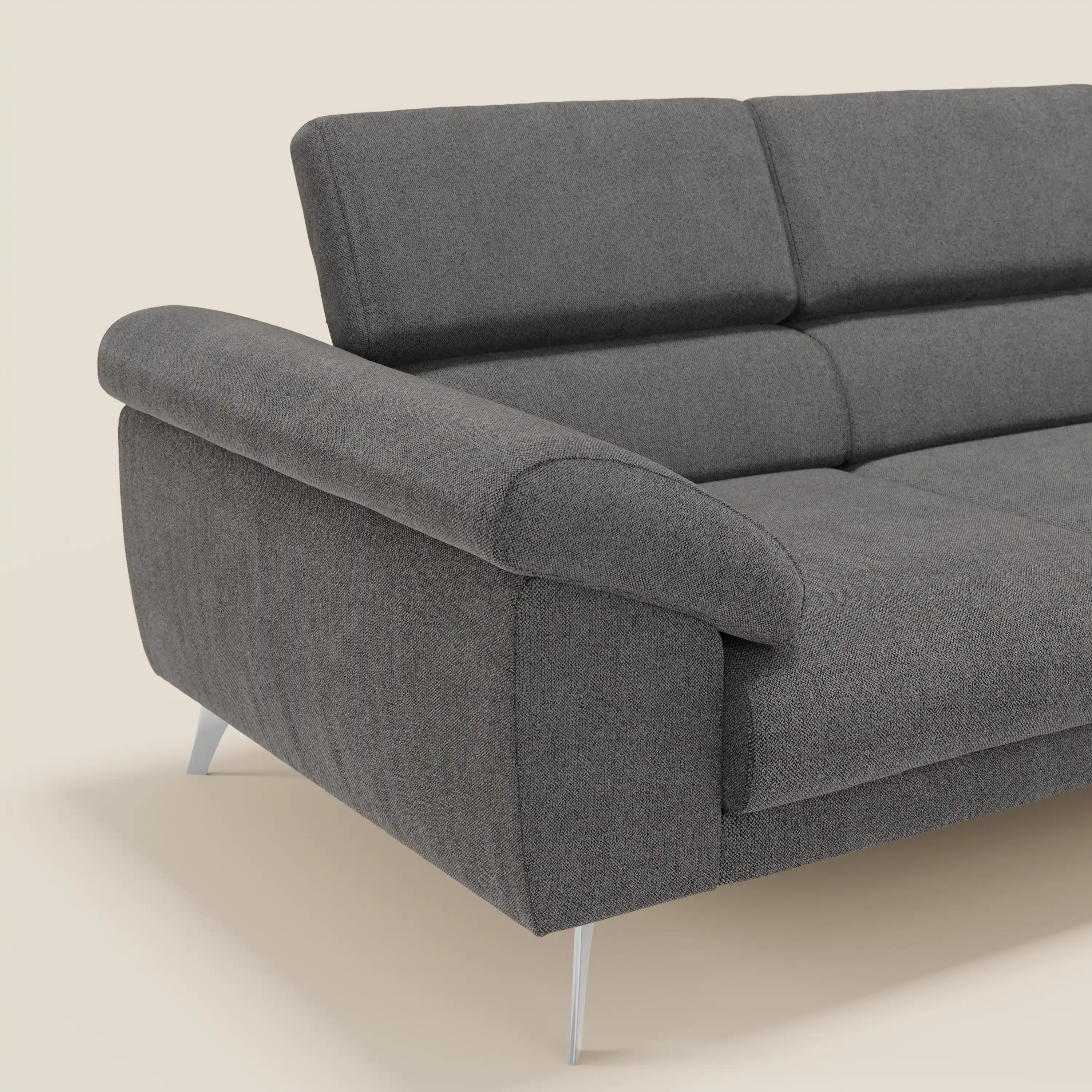 Il divano Donatello di Divani.Store è un divano contemporaneo a 3 posti di colore grigio scuro, con poggiatesta reclinabili, braccioli contenitori e tessuto antracite T23 antimacchia. È dotato di cuscini in tessuto e di eleganti gambe in metallo; solo un angolo appare sullo sfondo beige.